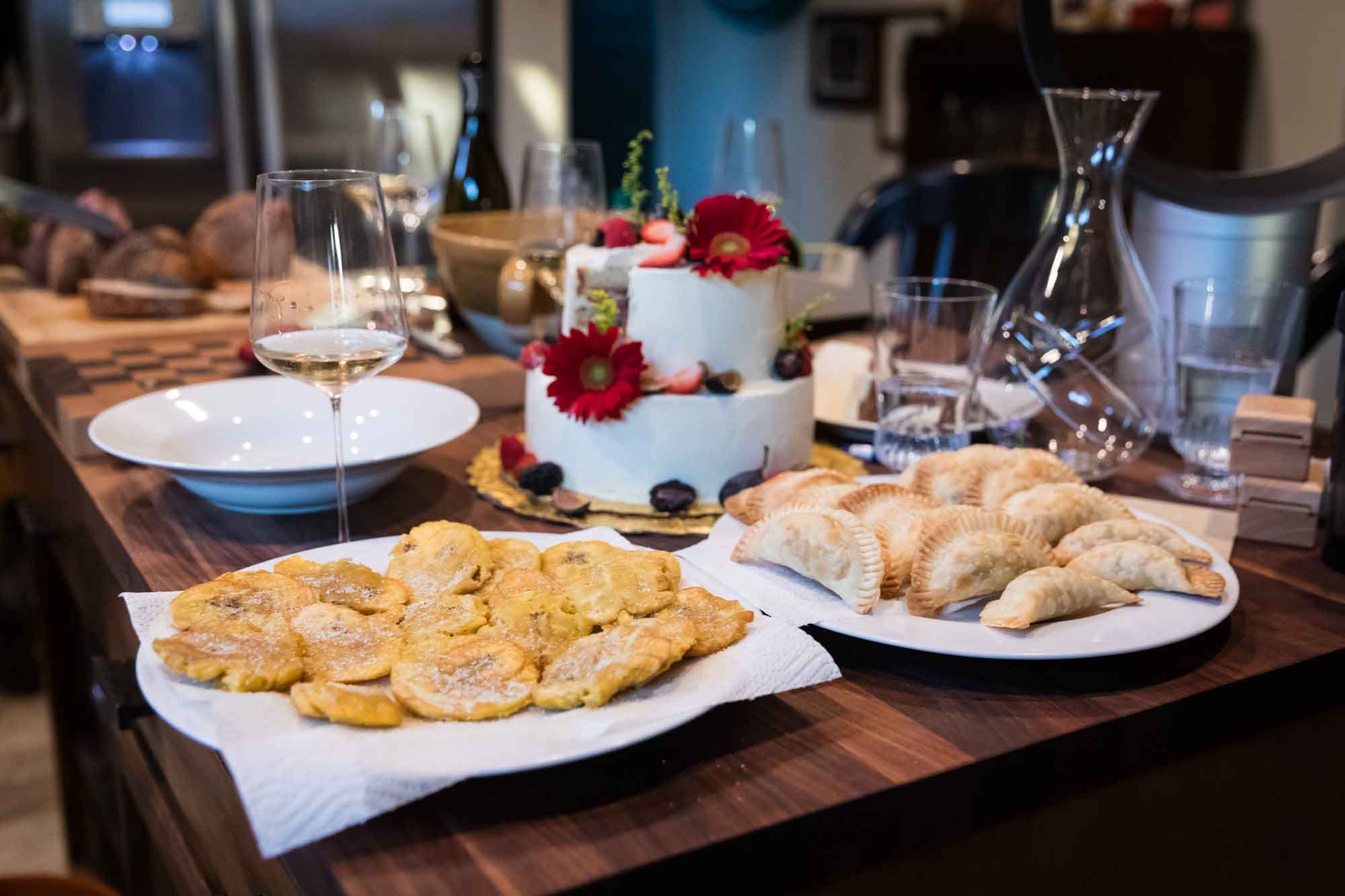 Table of homemade food and a wedding cake in a kitchen for an article on affordable wedding venues in San Antonio