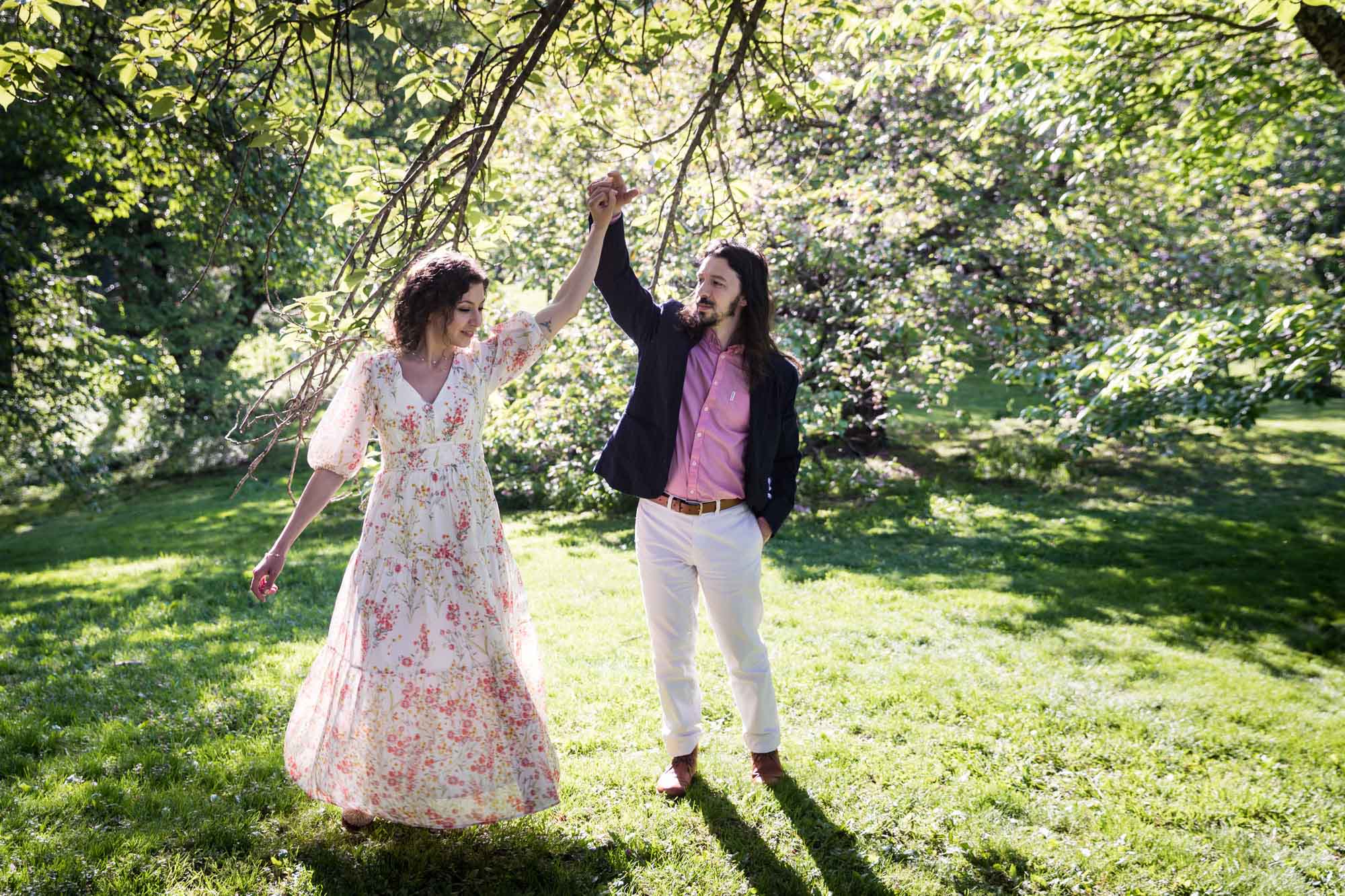 Couple dancing in grass under tree branches for an article on the best San Antonio Botanical Garden photo locations