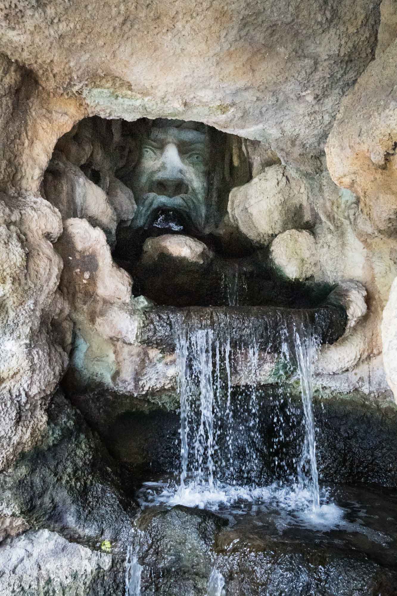 Carved stone face waterfall in the Grotto sculpture at the River Walk
