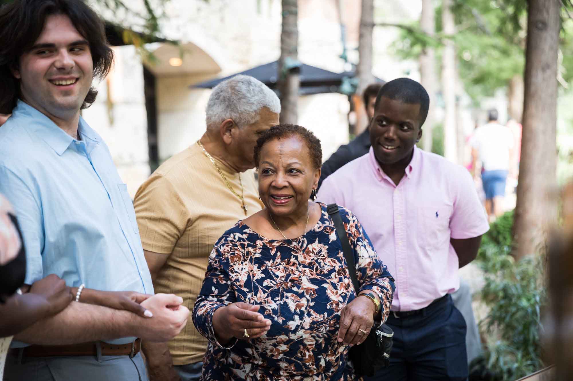 Older African American couple, African American man, and white man standing in front of trees waiting River Walk boat for an article on how to get married on a River Walk boat
