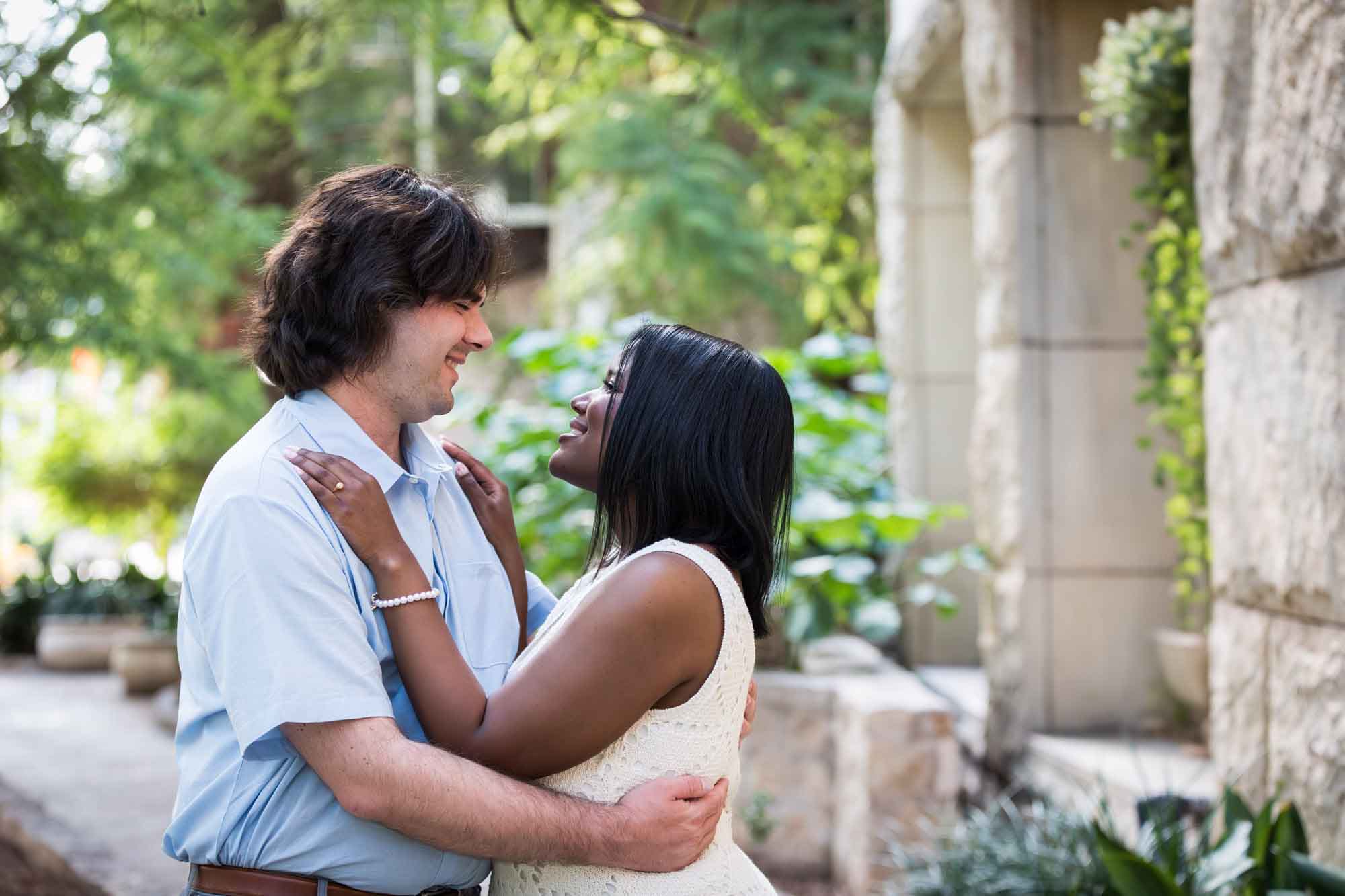 African American woman wearing white sleeveless dress hugging fiance wearing blue shirt for an article on how to get married on a River Walk boat