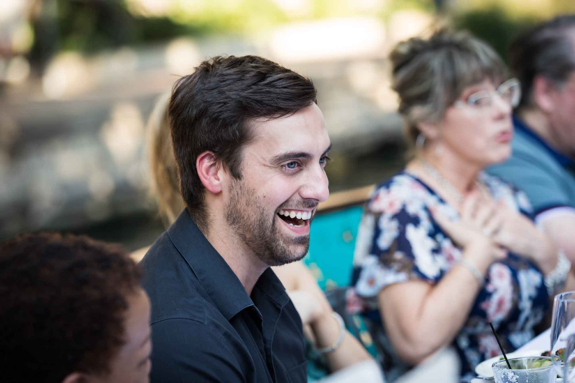 Man with goatee and brown hair smiling surrounded by guests for an article on how to get married on a River Walk boat
