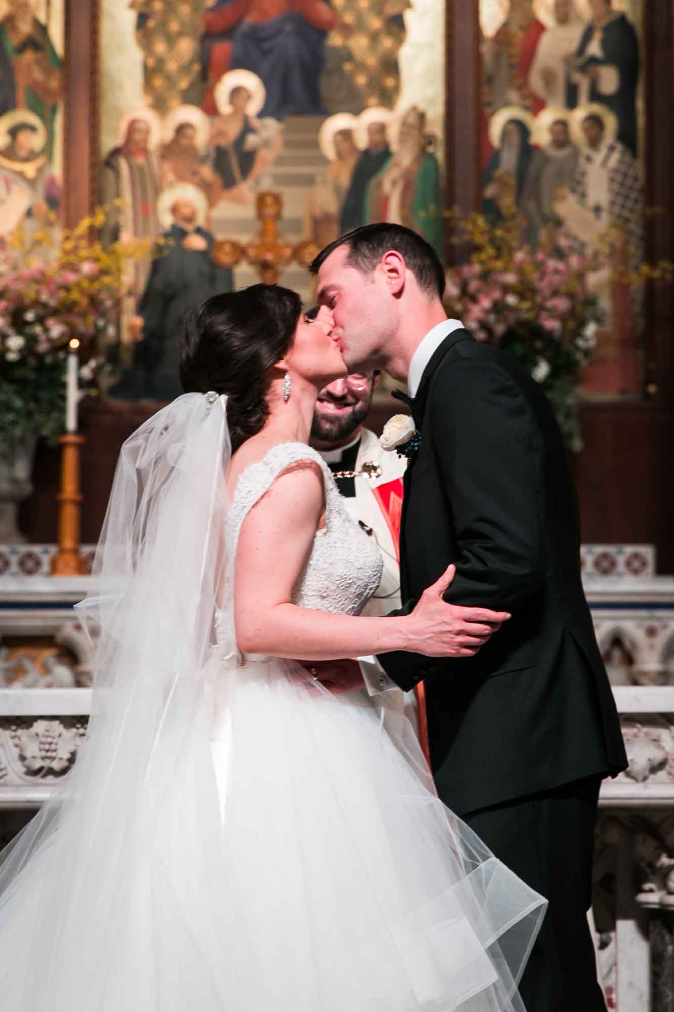 The kiss at a Fordham University Church wedding ceremony for an article on what to have ready when the wedding photographer arrives