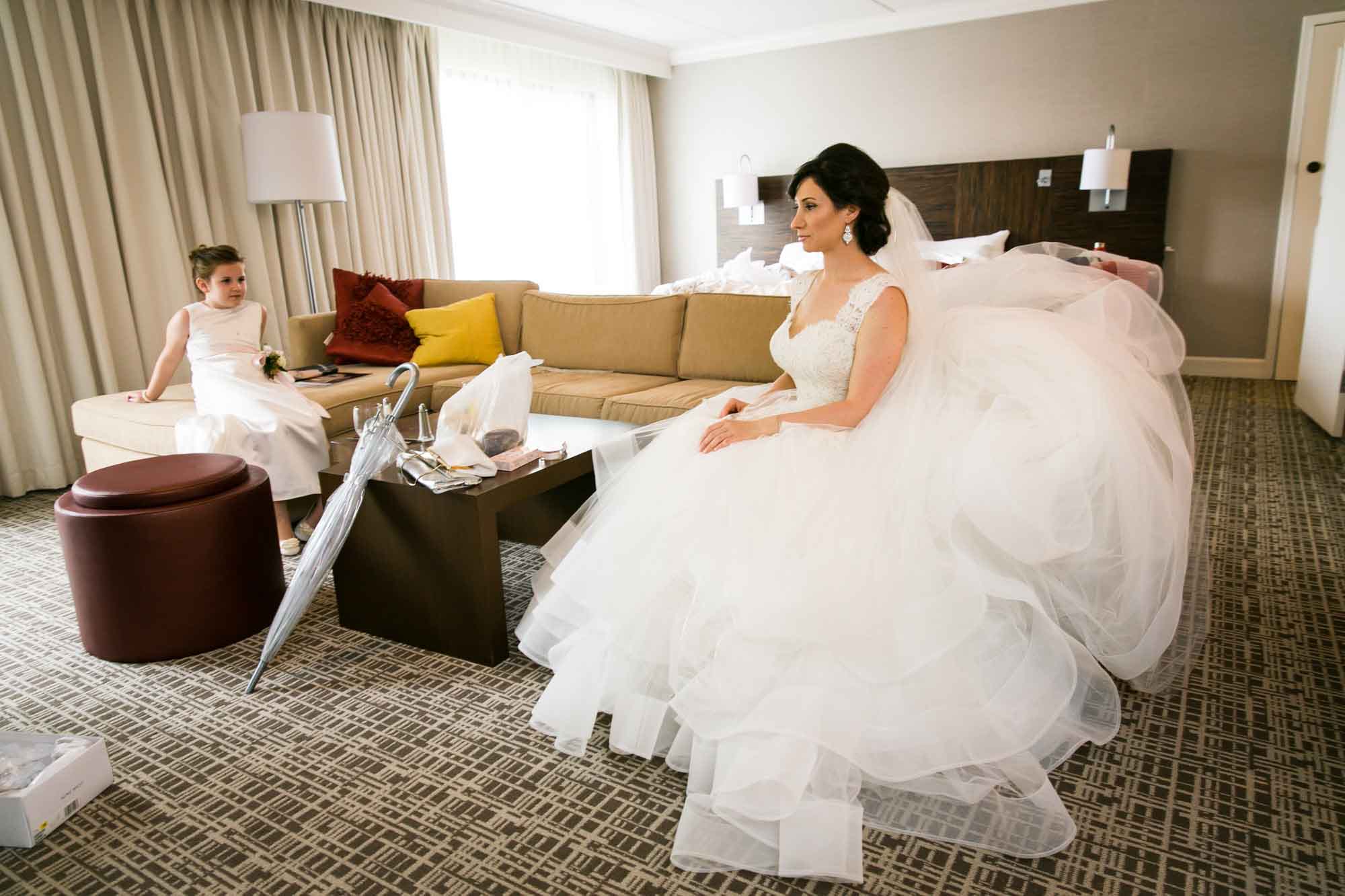 Bride sitting on couch before her Fordham University Church wedding for an article on what to have ready when the wedding photographer arrives