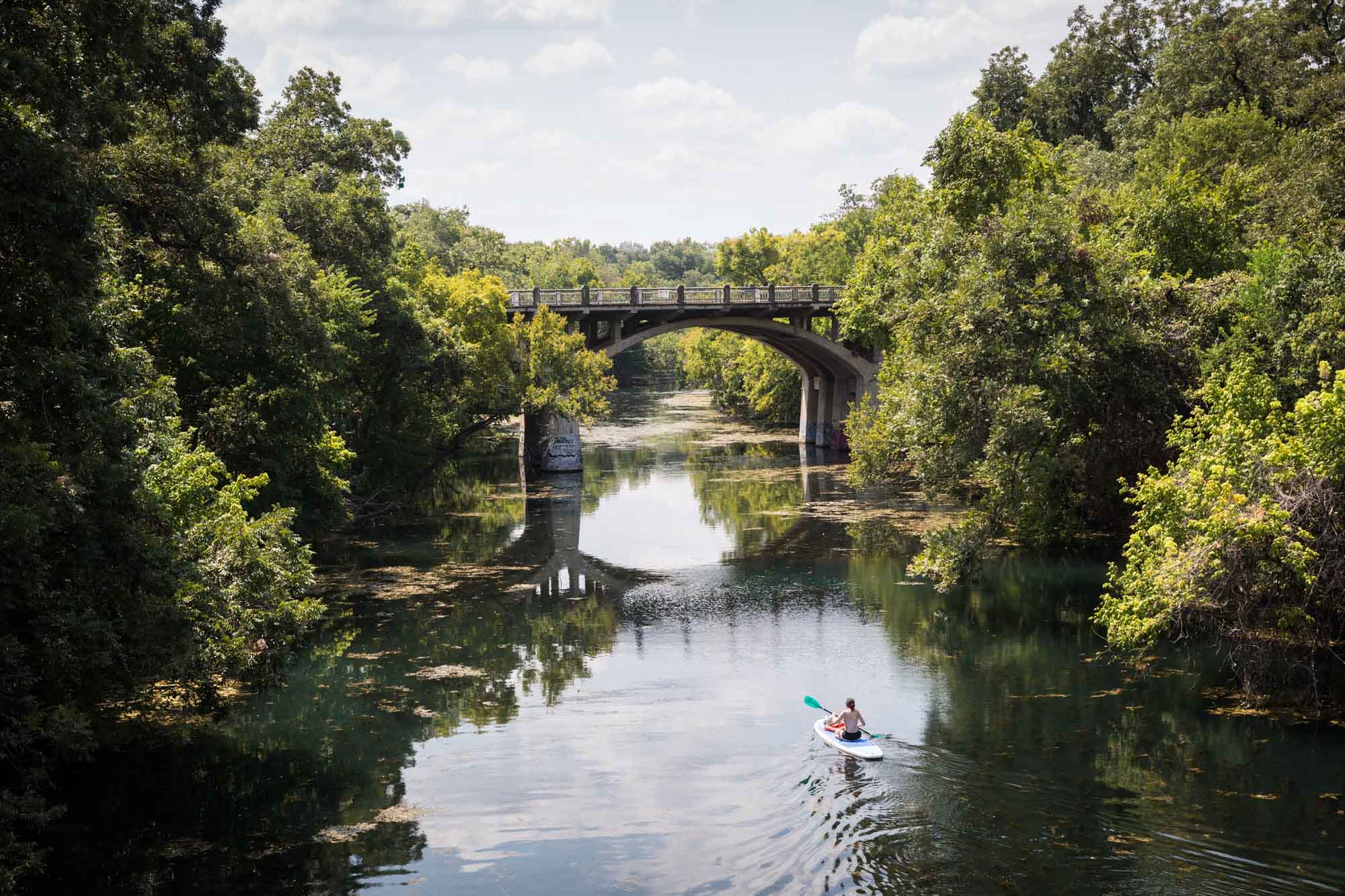 Kayaker floating down Barton Creek in Zilker Metropolitan Park
