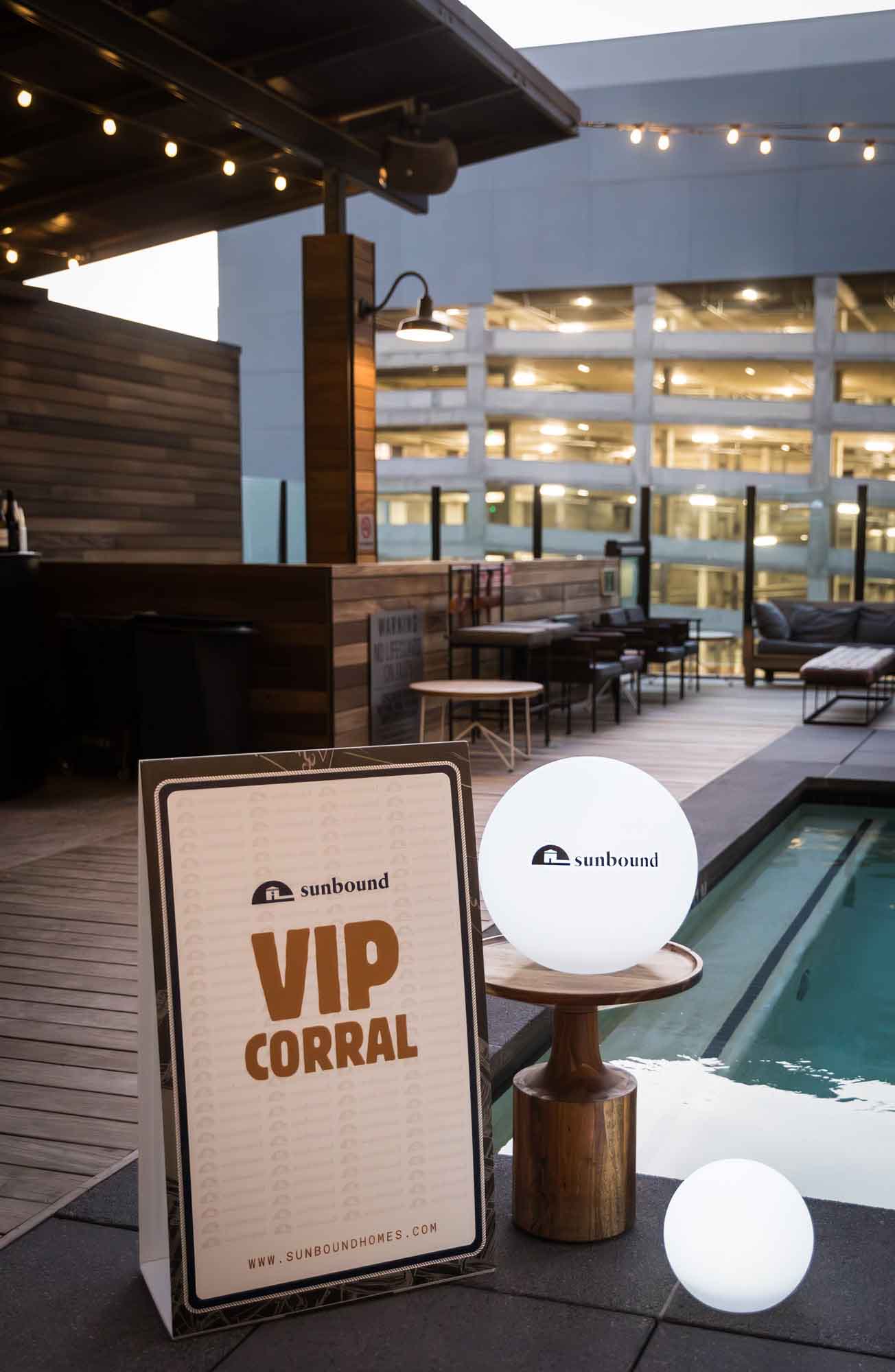 VIP Corral sign next to round lit sign showing sponsor name during corporate event at Hotel Van Zandt