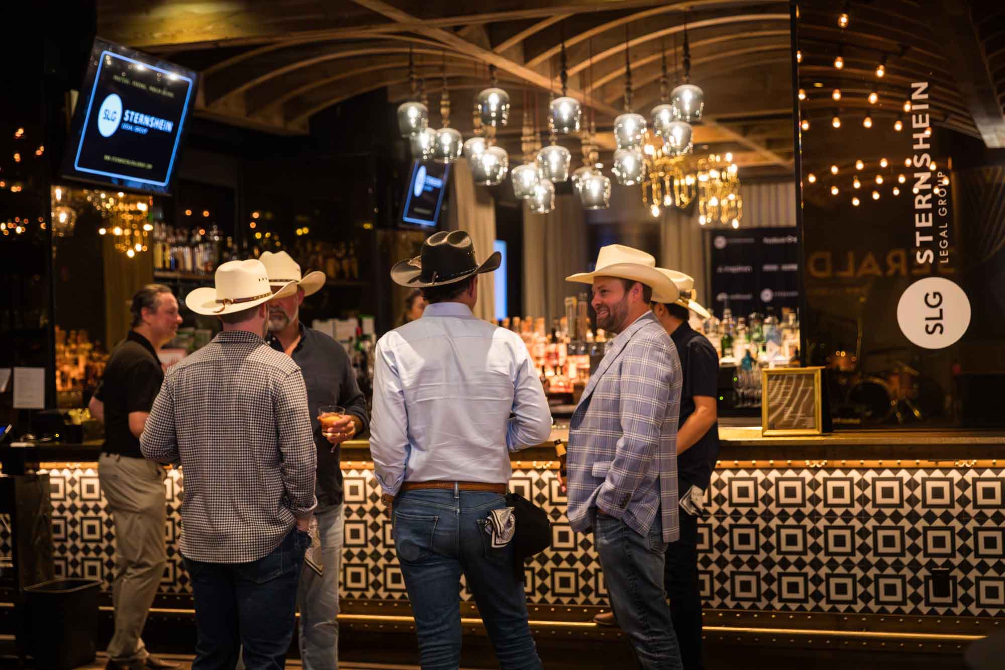 Male guests at the bar wearing cowboy hats during a Hotel Van Zandt corporate event