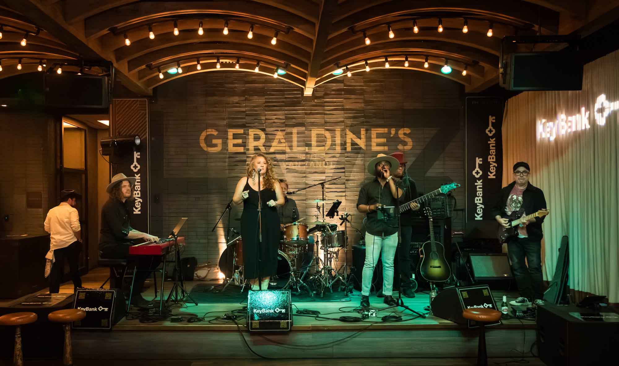 London Calling band performing on stage with Geraldine's sign in back of stage during a Hotel Van Zandt corporate event