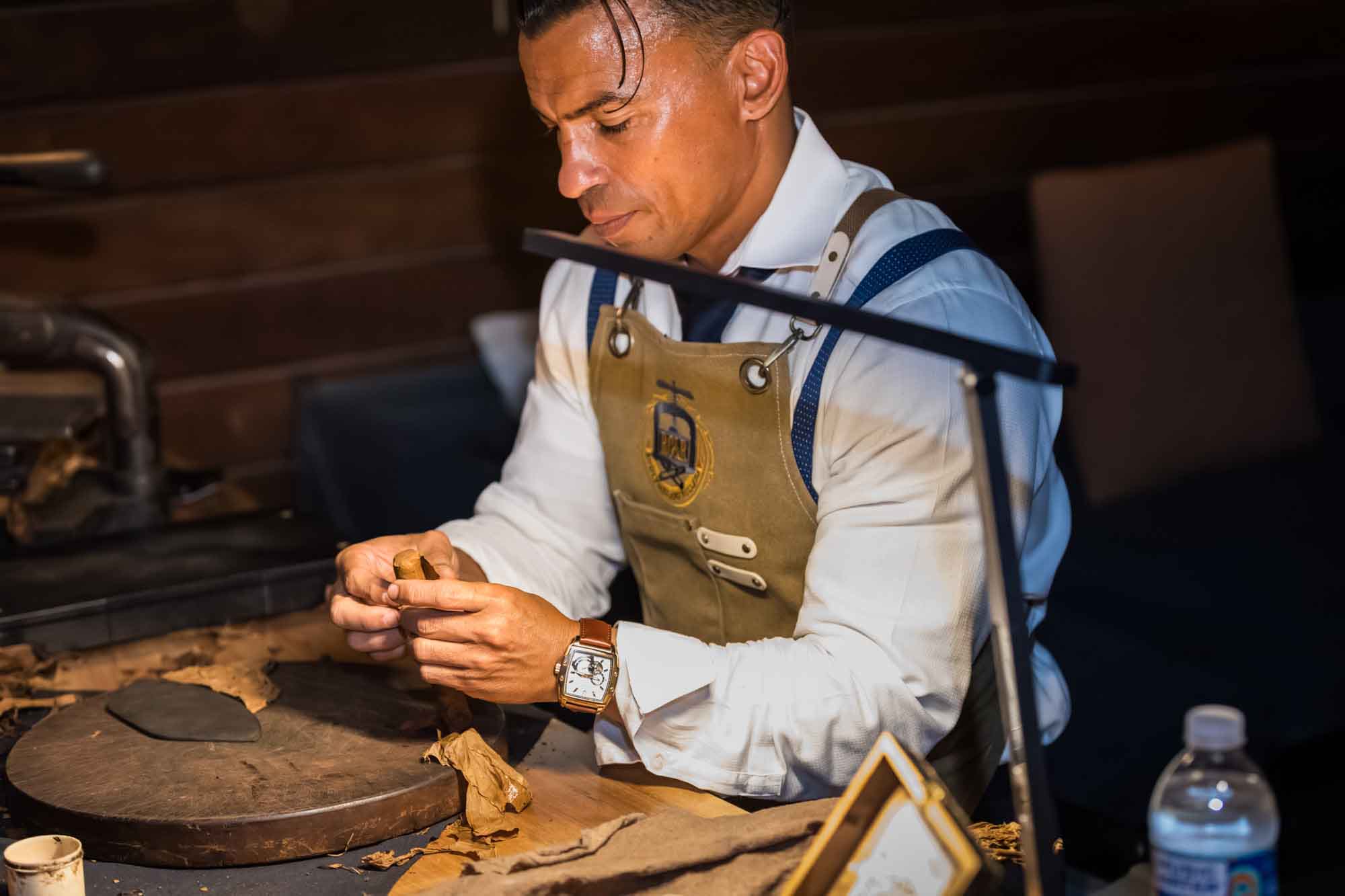 Ibrahim Ruiz rolling a cigar at a table during a Hotel Van Zandt corporate event