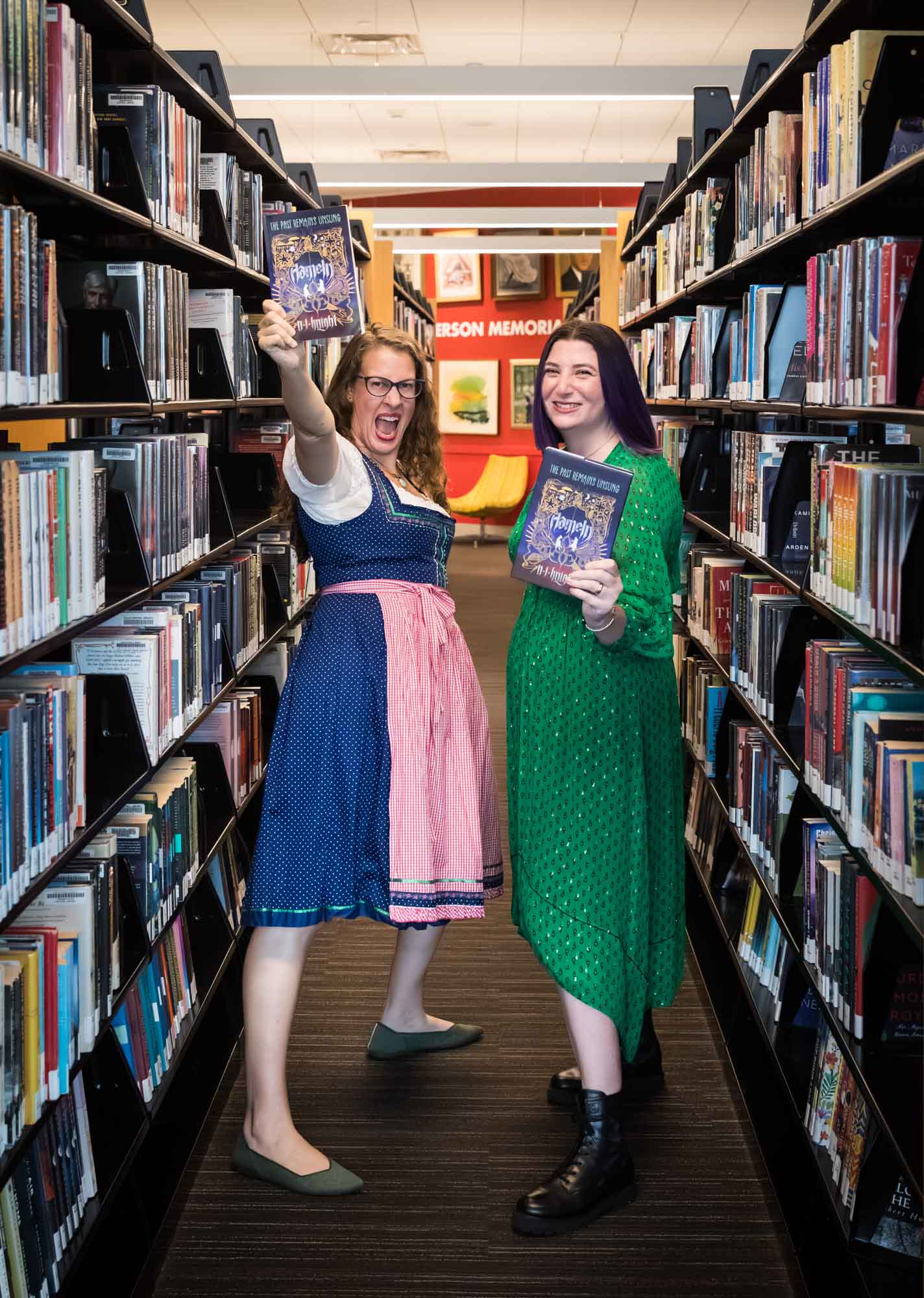 Author Nancy Knight and editor Britta Jensen holding books in front of bookshelves for an article on how to take photos in the Austin Central Library