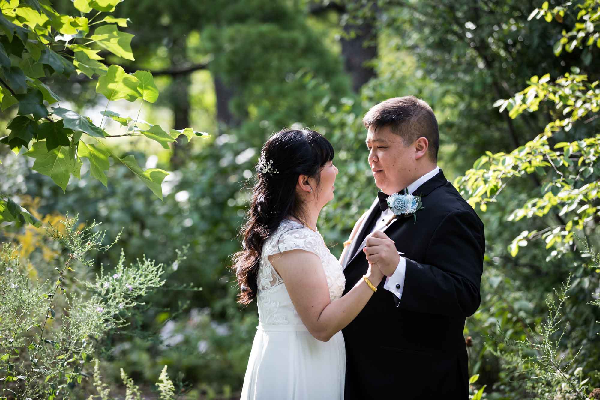 Bride and groom dancing in garden with trees in background for an article on outdoor wedding tips
