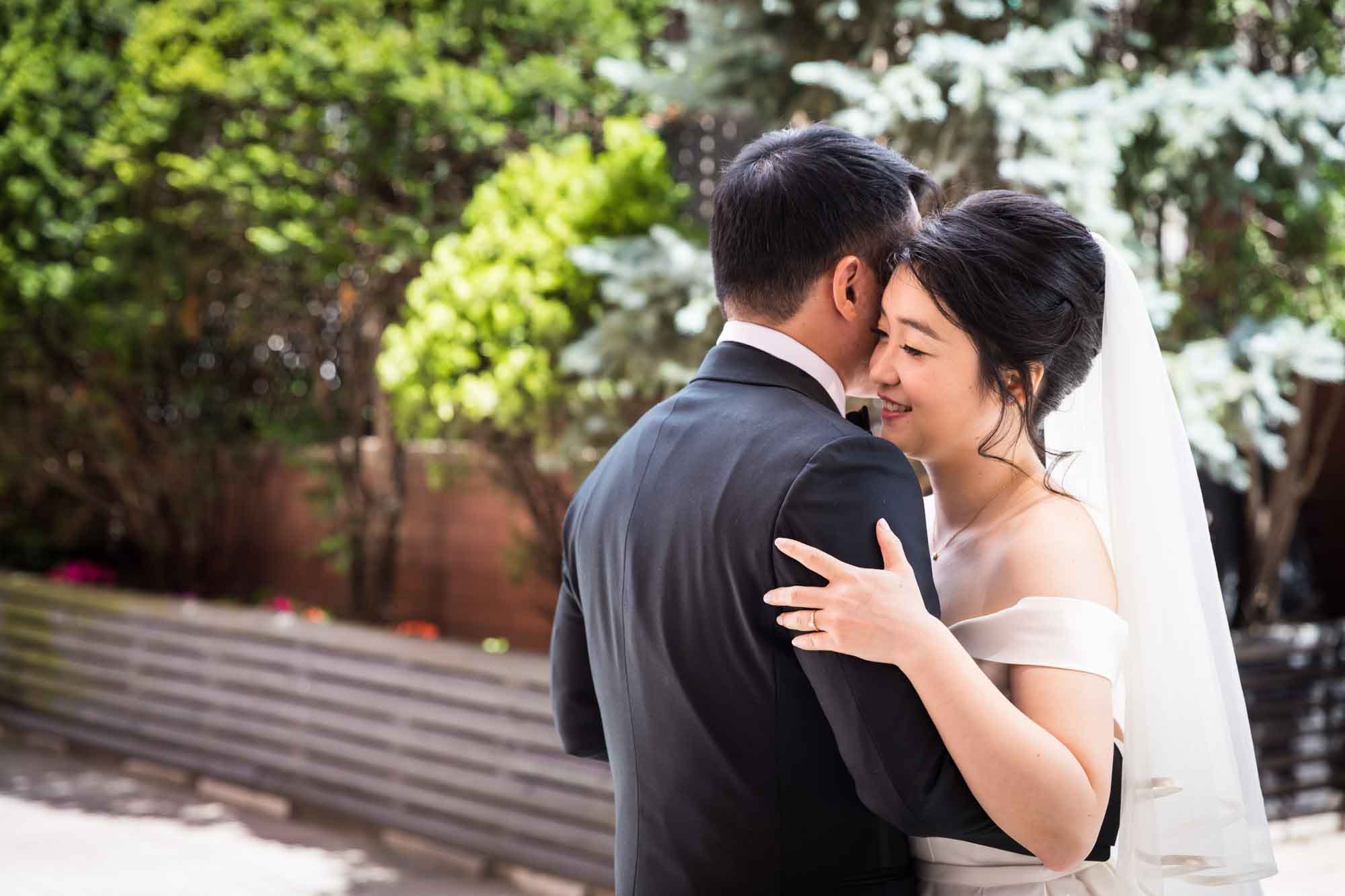 Bride and groom dancing on patio with bushes and flowers in background for an article on outdoor wedding tips