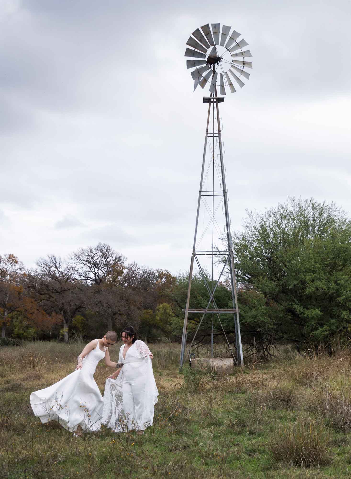Two brides wearing white dresses with windmill to the right for an article on outdoor wedding tips