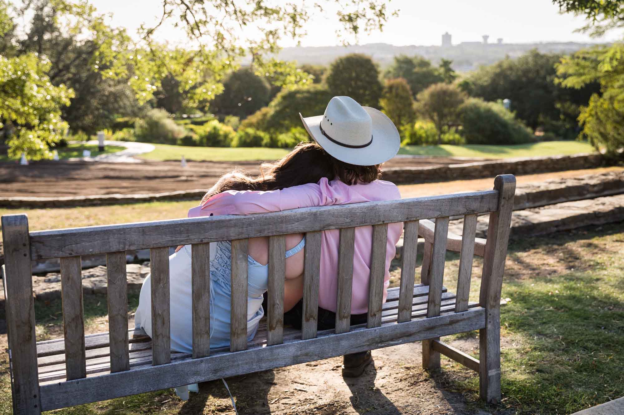 San Antonio Botanical Garden engagement photos of couple sitting on bench at the Overlook