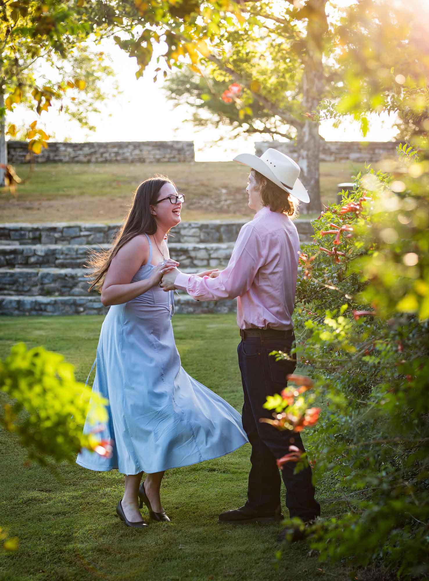 San Antonio Botanical Garden engagement photos of couple dancing in front of vines at the Amphitheater