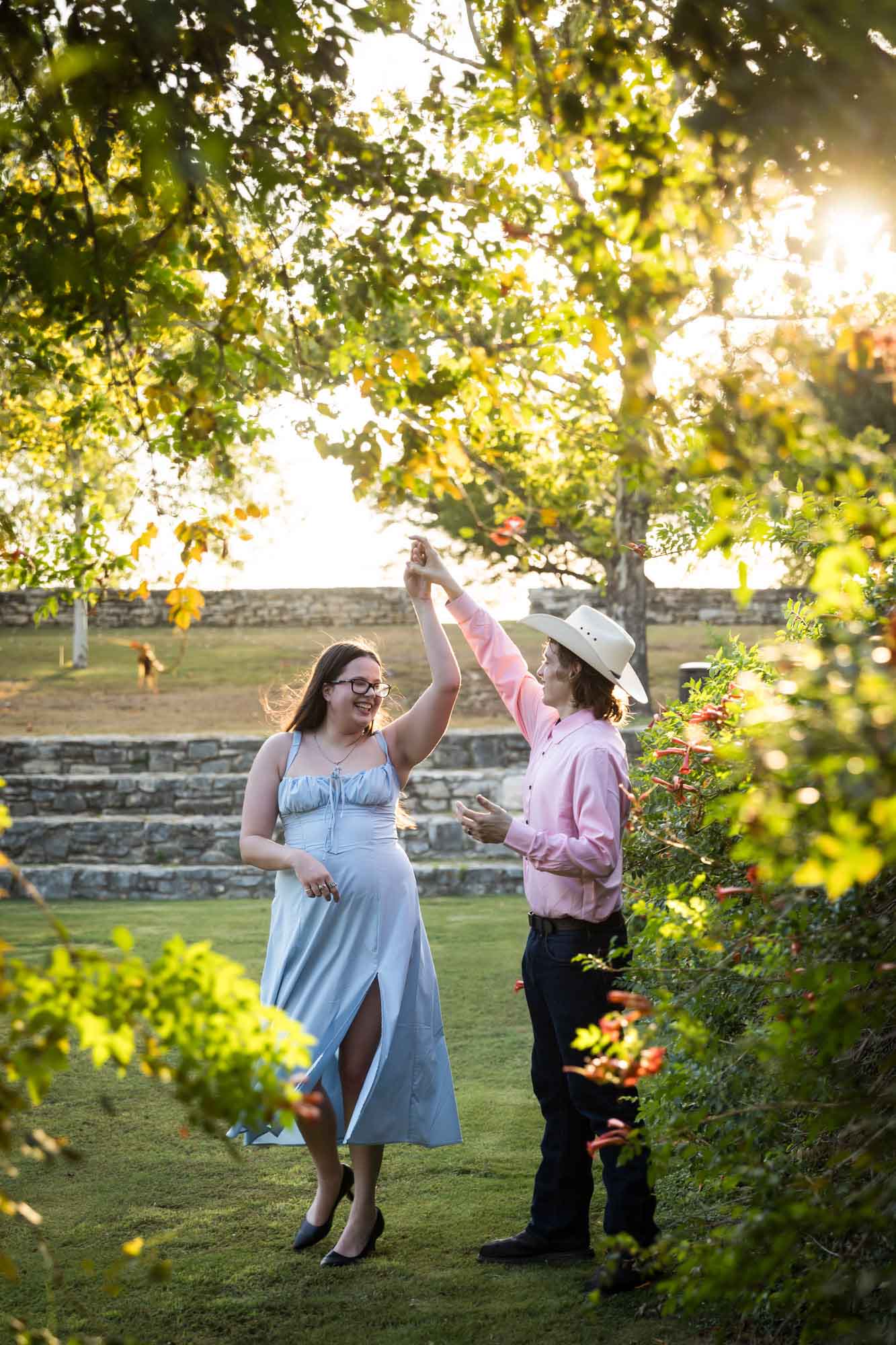 San Antonio Botanical Garden engagement photos of couple dancing in front of vines at the Amphitheater