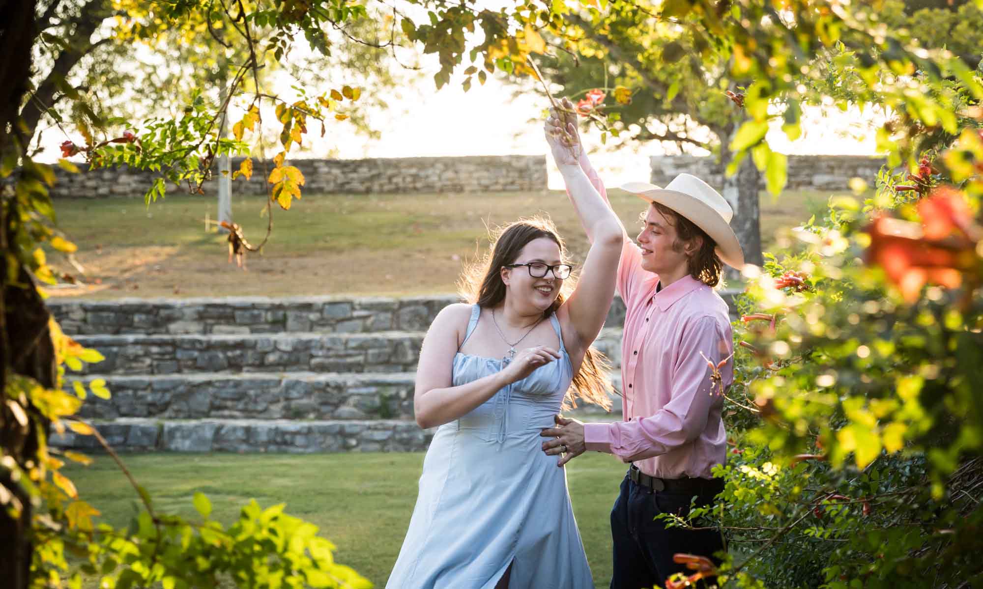 San Antonio Botanical Garden engagement photos of couple dancing in front of vines at the Amphitheater