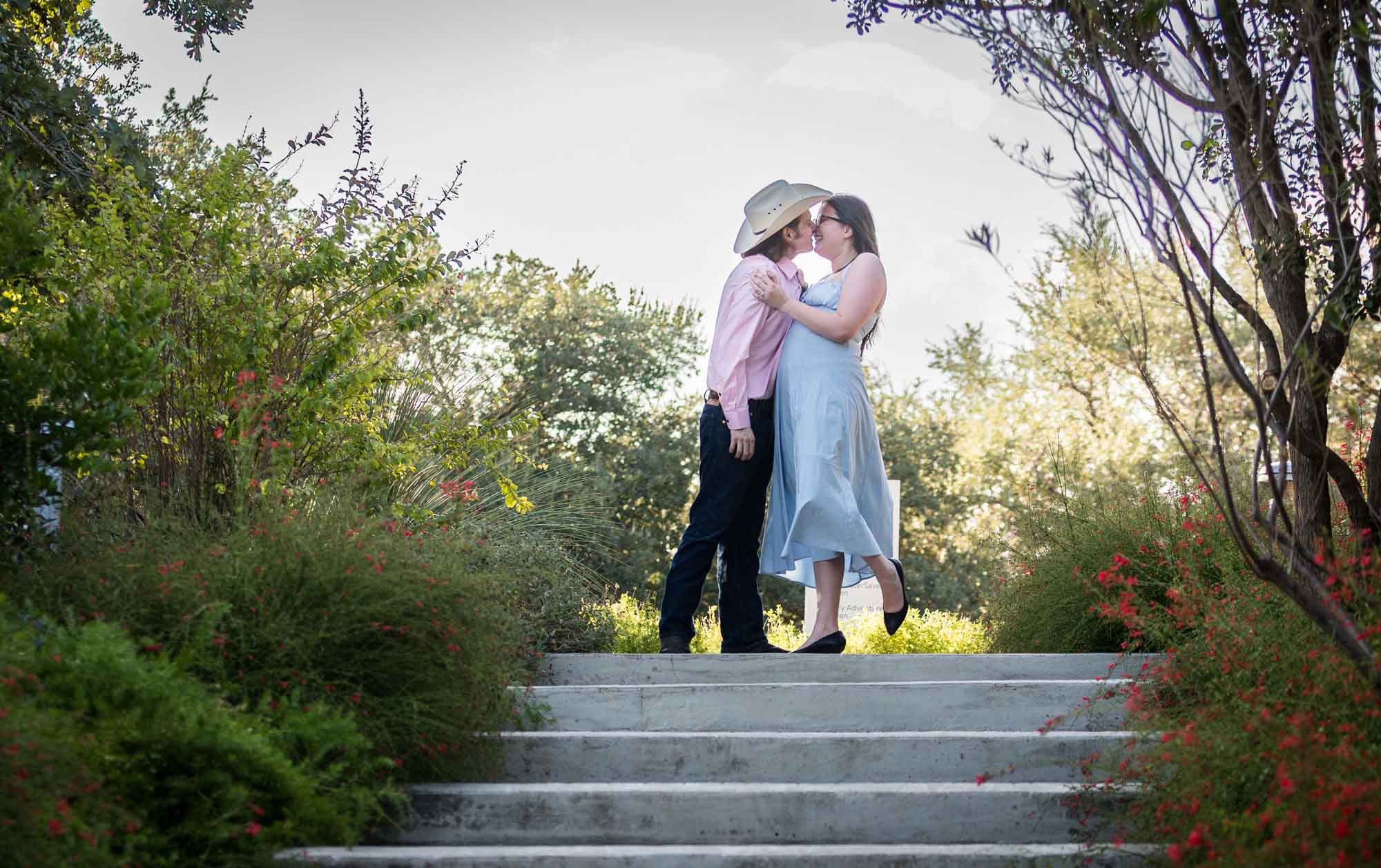 San Antonio Botanical Garden engagement photos of couple kissing at top of staircase