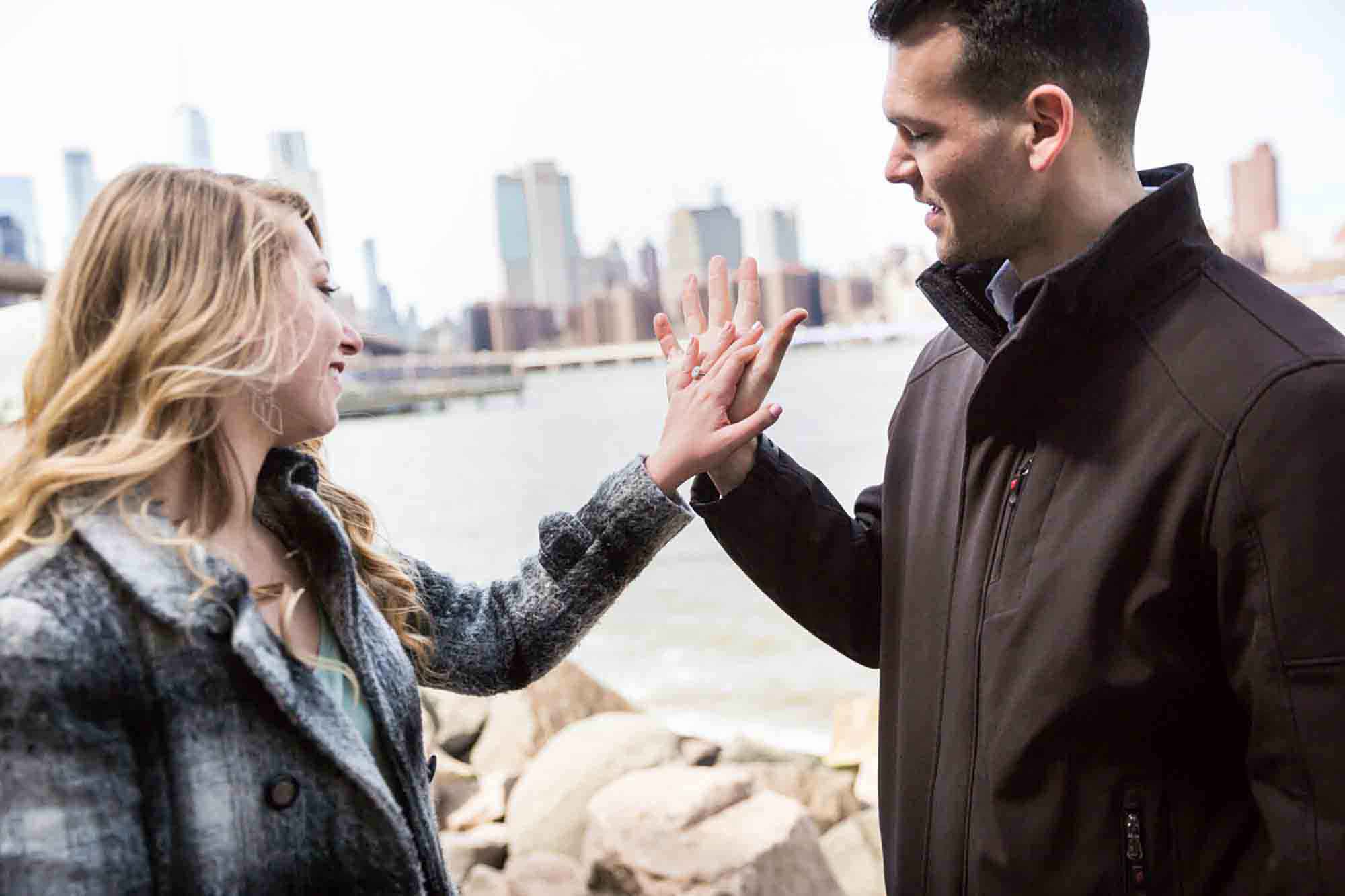 Couple holding hands looking at engagement ring on woman's hand for an article on the best places to propose in Austin