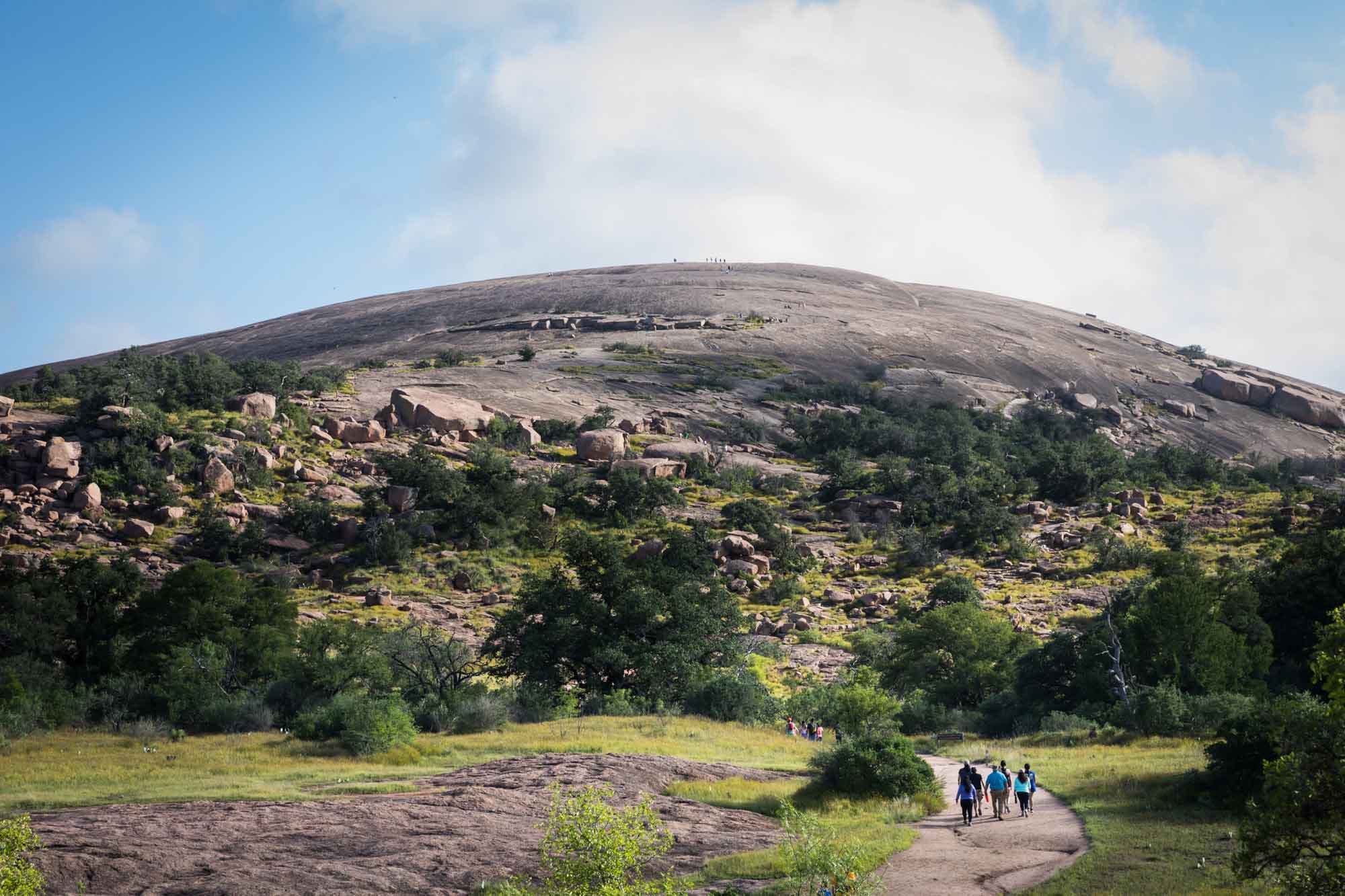 Hikers beginning to climb up Enchanted Rock for an article on the best places to propose in Austin