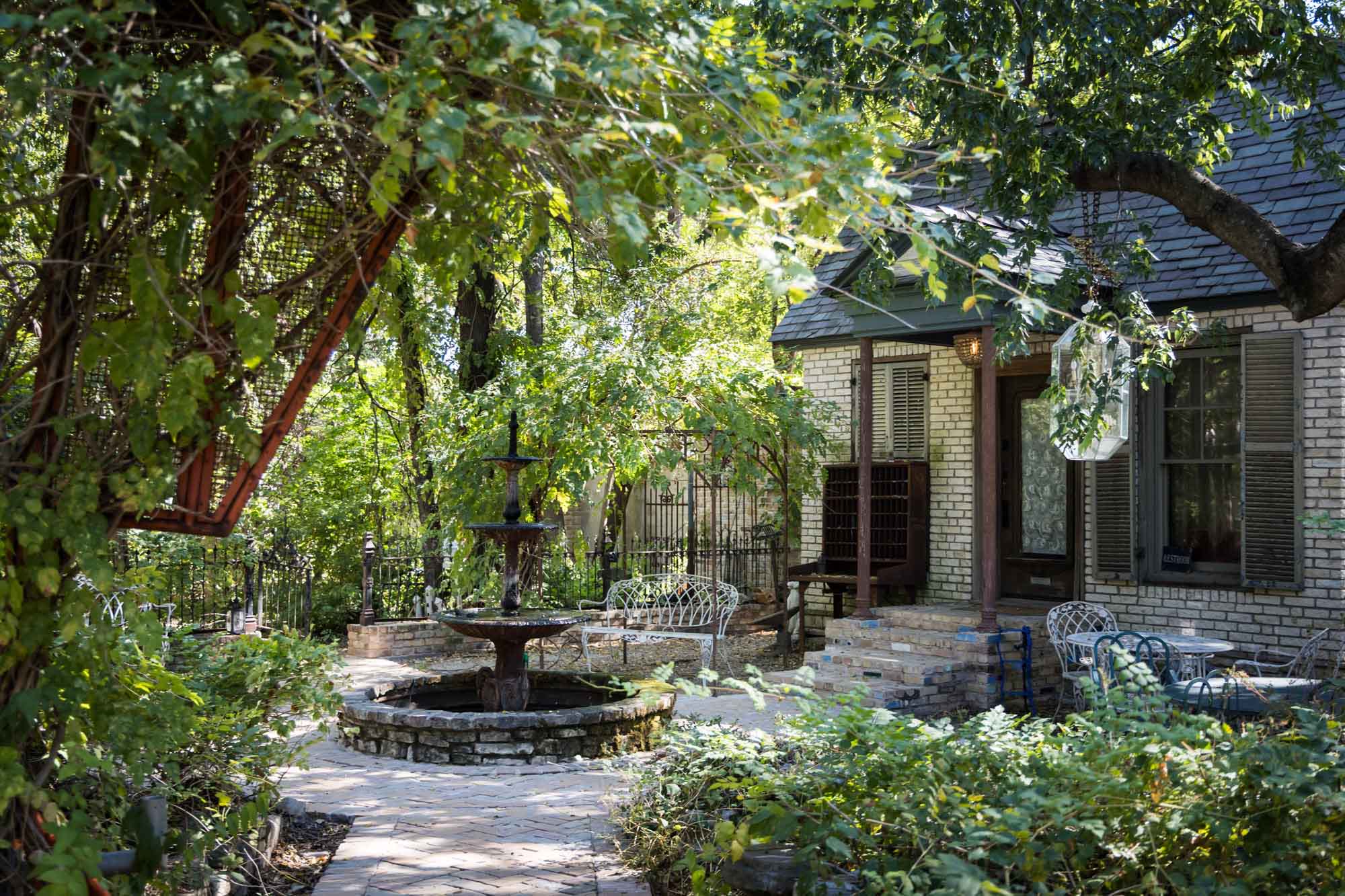 Backyard with fountain and iron patio furniture at the Sekrit Theater for an article on the best places to propose in Austin