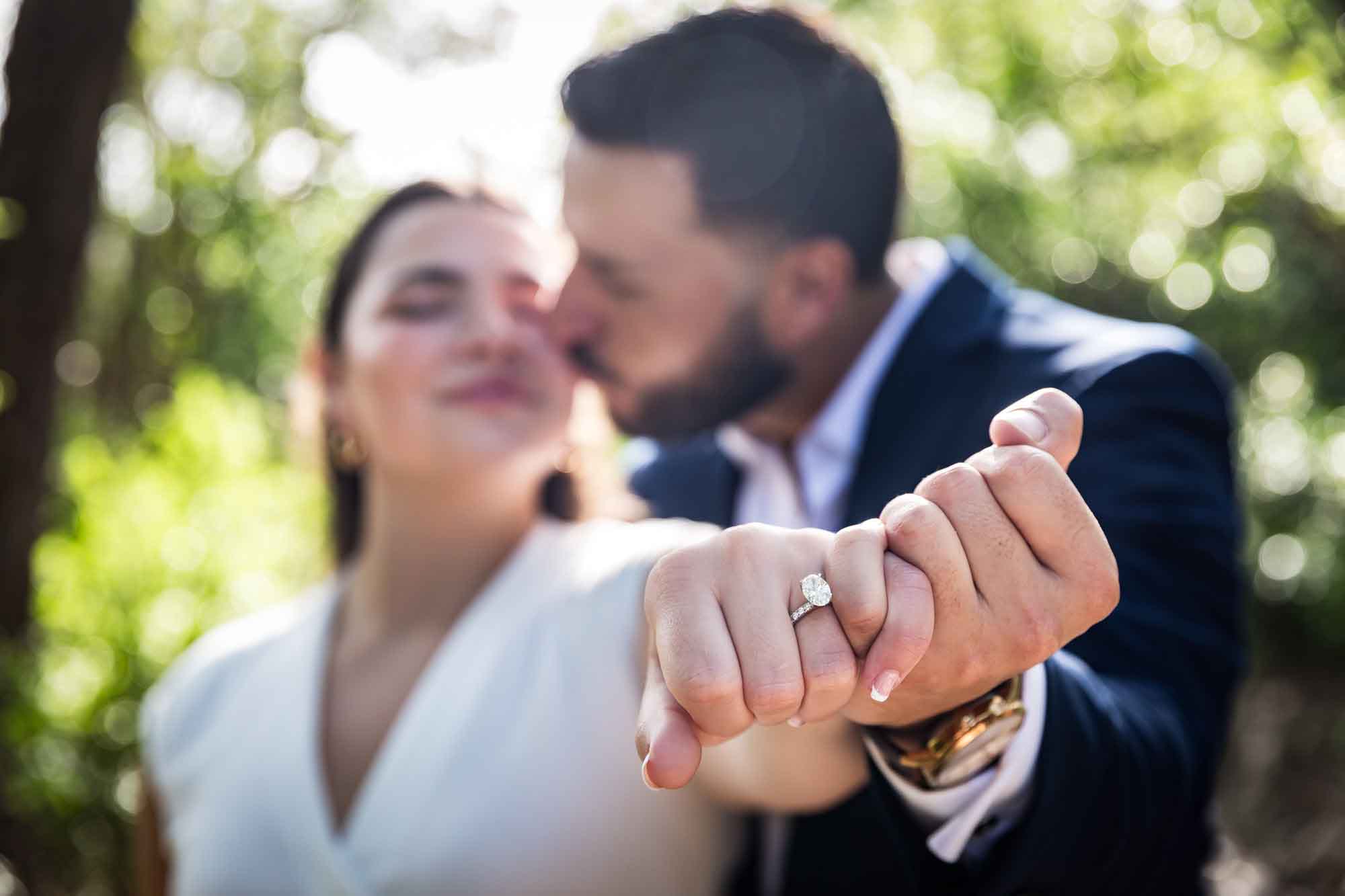 Couple clasping hands and showing woman wearing engagement ring to camera for an article on Cibolo Nature Center surprise proposal tips