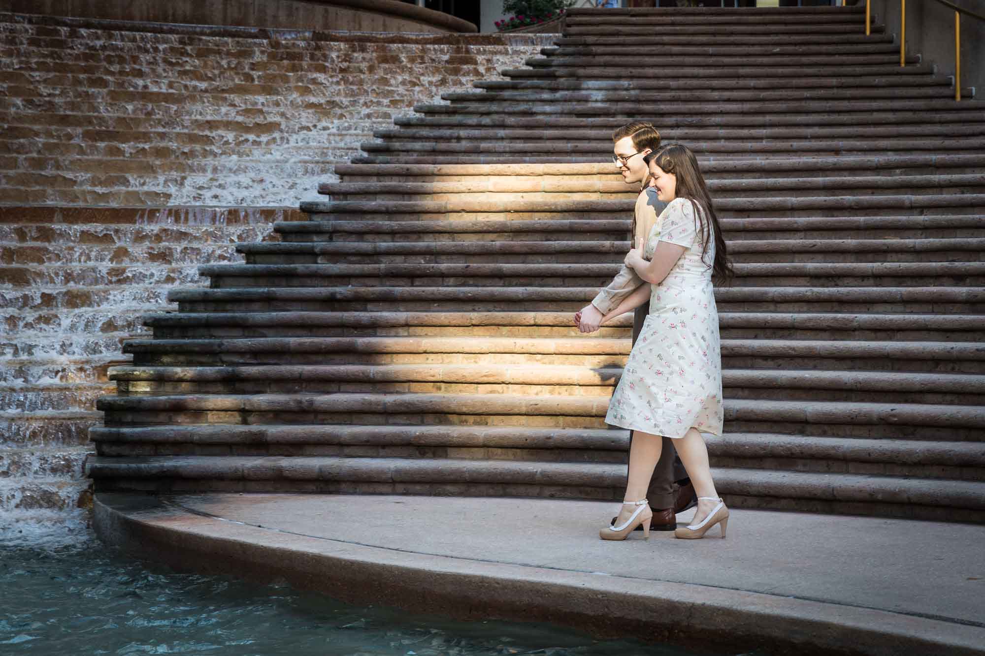 Couple walking together in front of staircase at Weston Centre during a River Walk surprise proposal