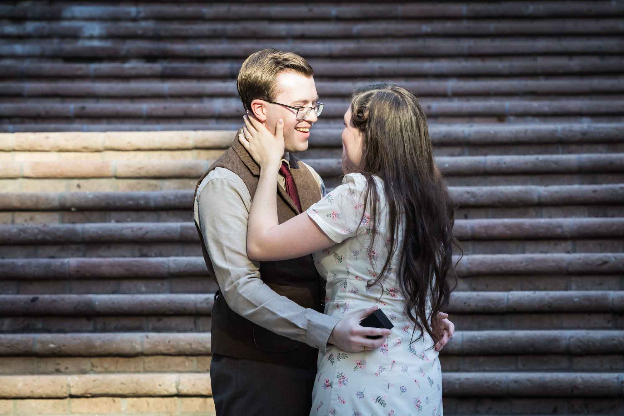 Couple hugging in front of staircase at Weston Centre during a River Walk surprise proposal