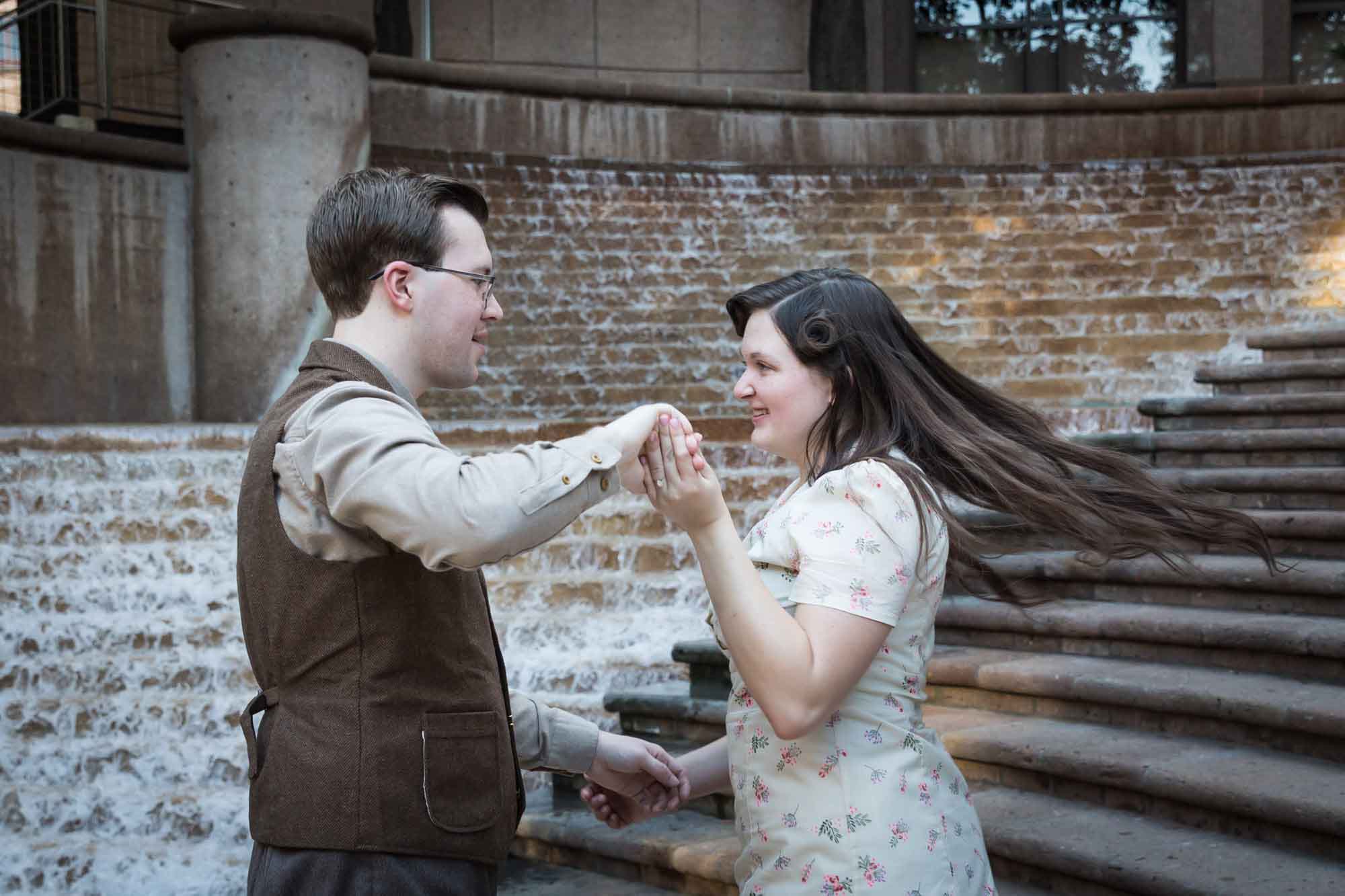 Couple dancing in front of waterfall and stairs at Weston Centre during a River Walk surprise proposal