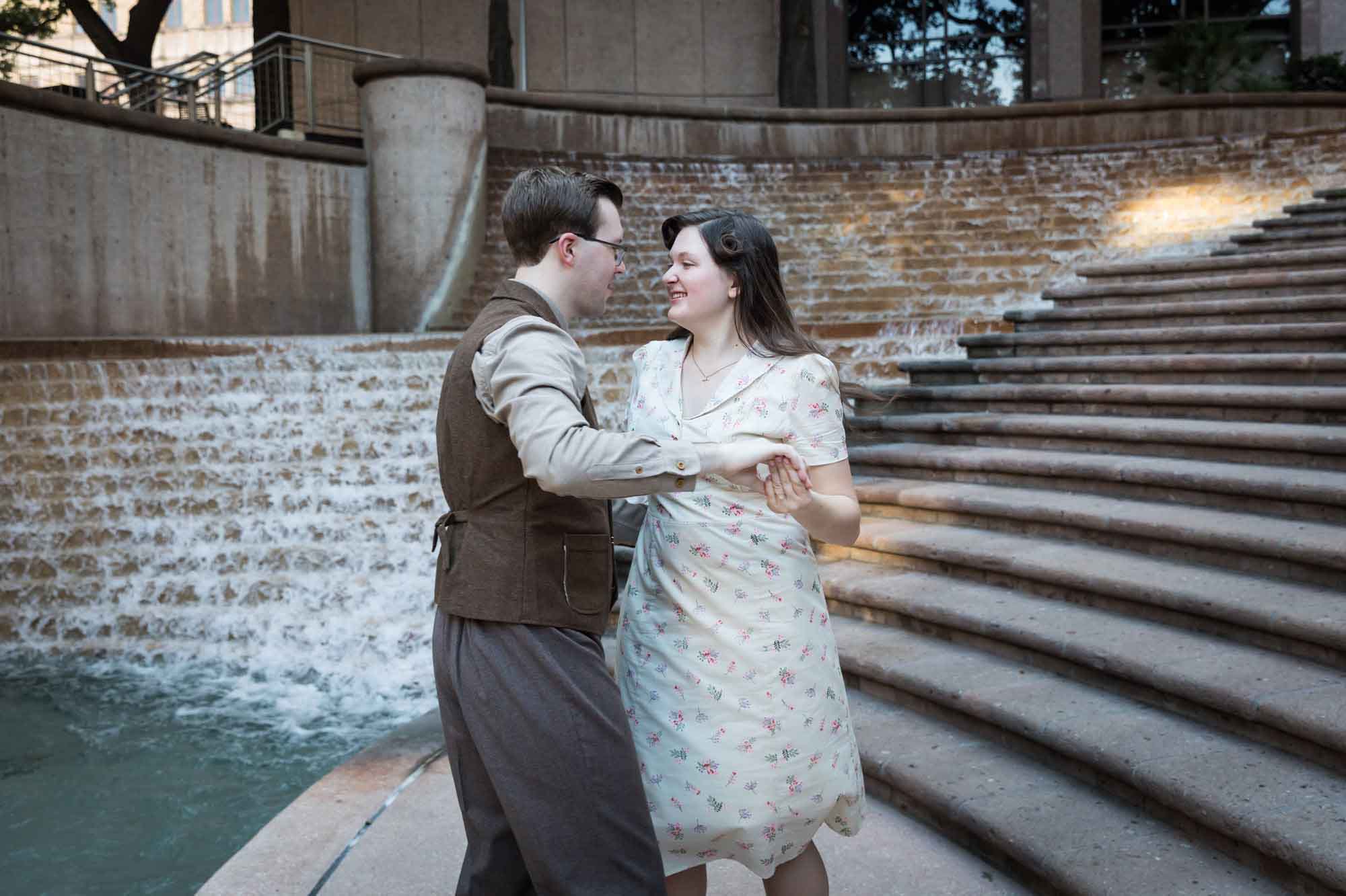 Couple dancing in front of waterfall and stairs at Weston Centre during a River Walk surprise proposal