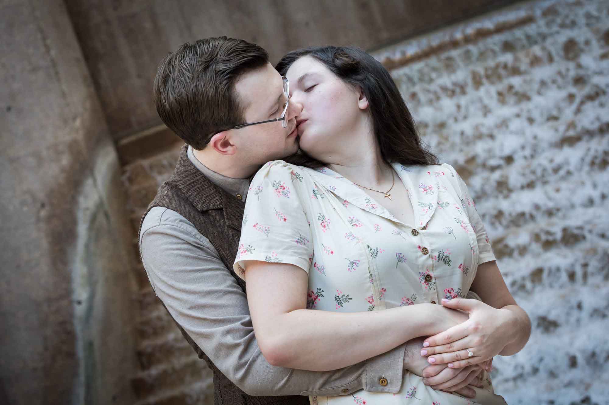 Couple kissing in front of waterfall and stairs at Weston Centre during a River Walk surprise proposal