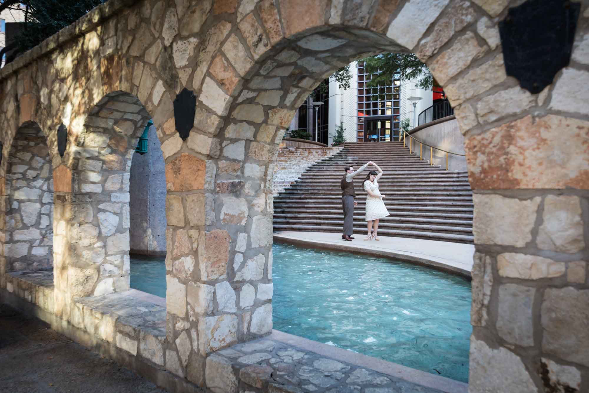 Couple dancing in front of waterfall and stairs at Weston Centre during a River Walk surprise proposal