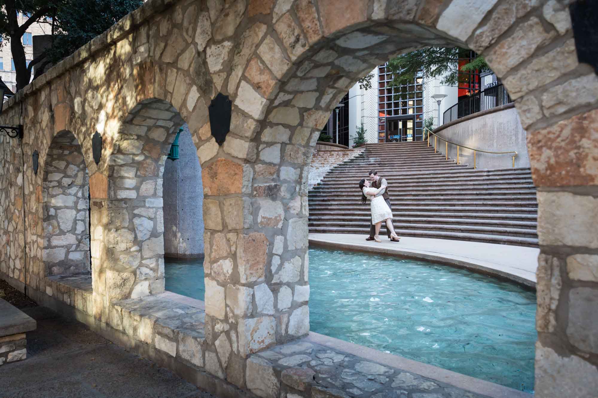 Couple dancing in front of waterfall and stairs at Weston Centre during a River Walk surprise proposal
