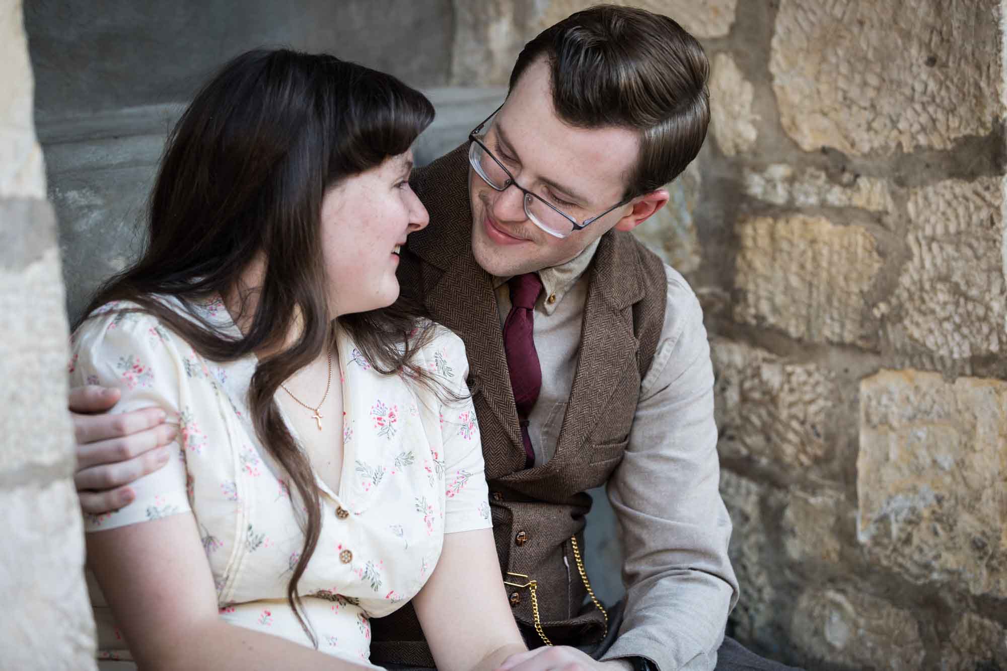 Couple hugging while seated in stone vestibule during a River Walk surprise proposal