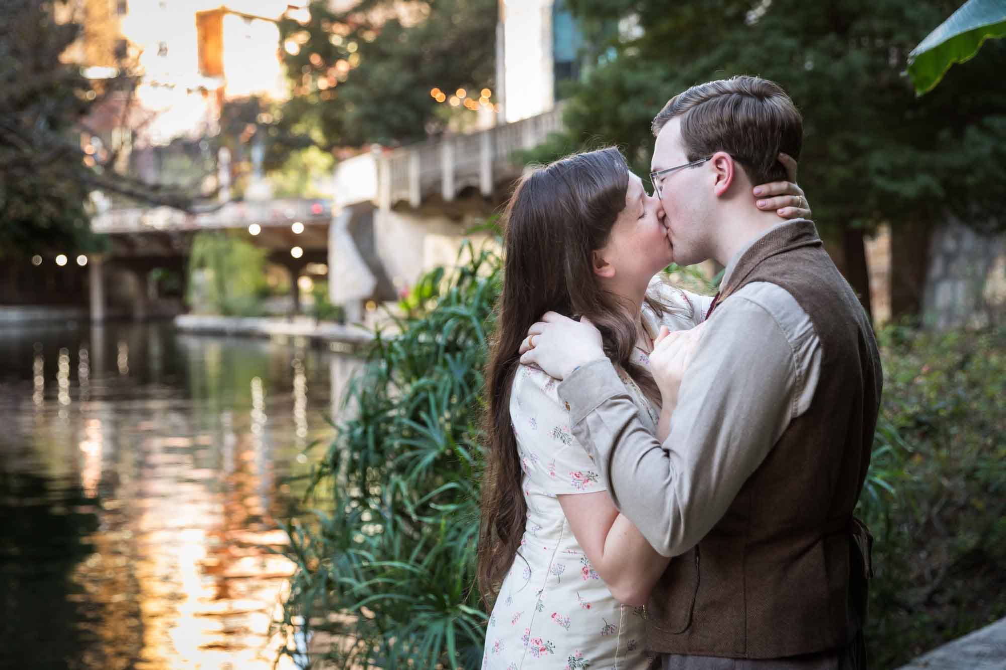 Couple kissing and surrounded by plants during a River Walk surprise proposal
