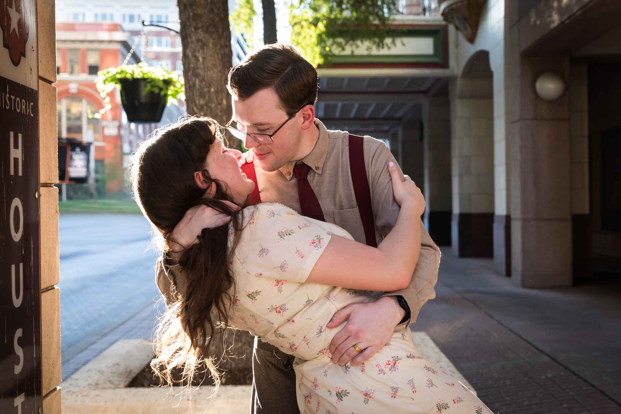 Man dipping woman in the street while wearing retro outfits from the 1940s during a River Walk surprise proposal
