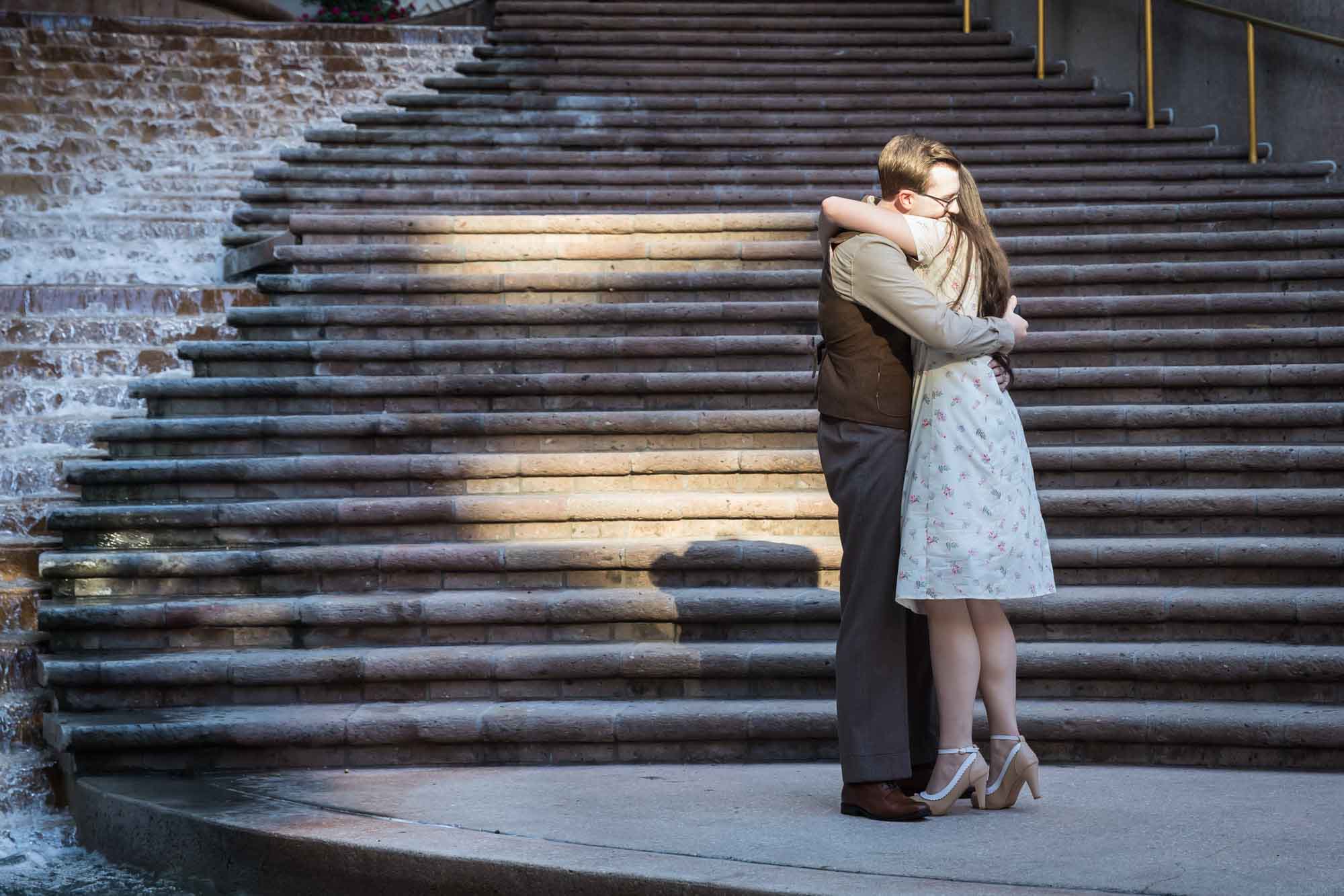 Couple hugging in front of staircase at Weston Centre during a River Walk surprise proposal