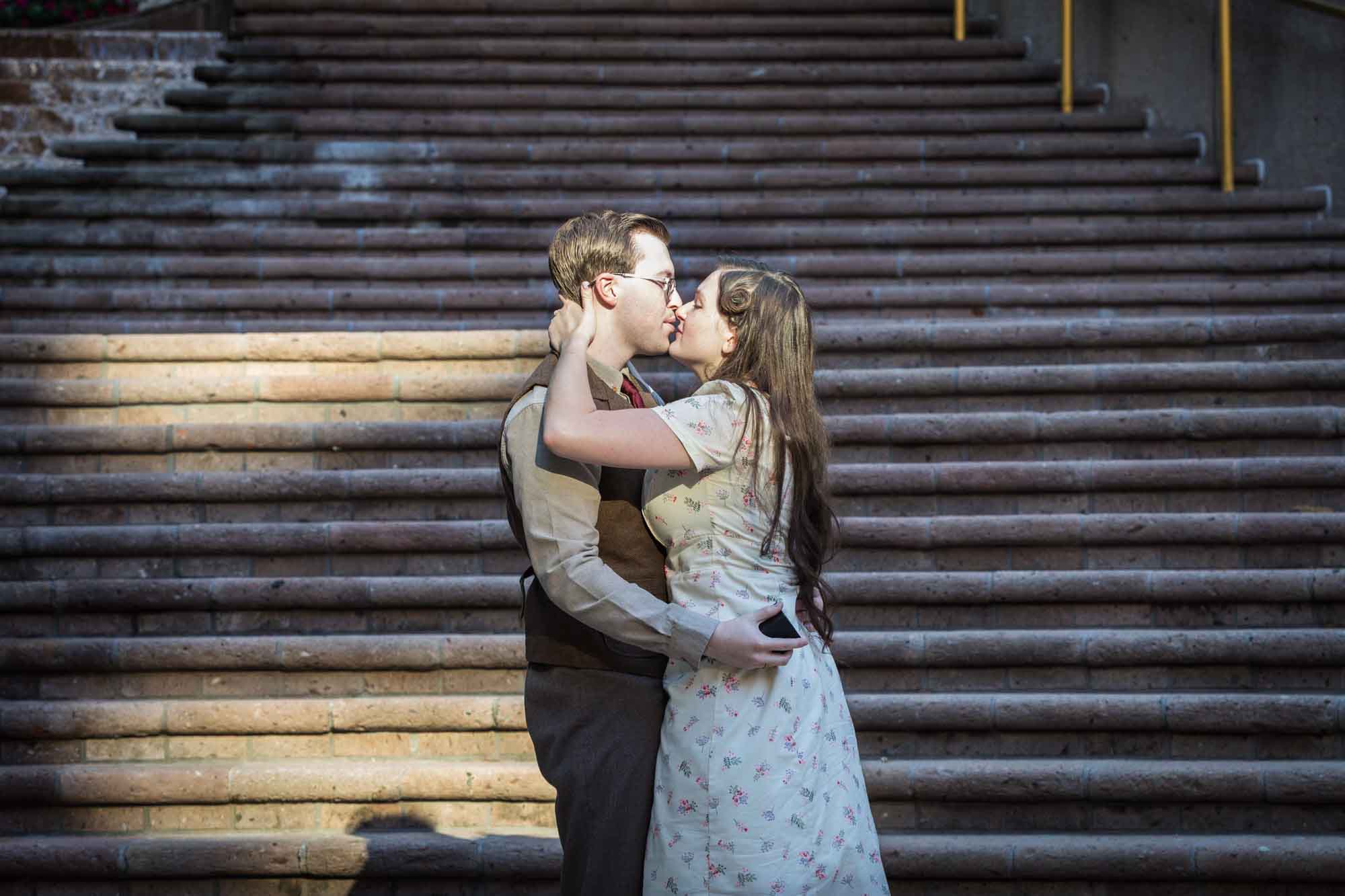 Couple kissing in front of staircase at Weston Centre during a River Walk surprise proposal
