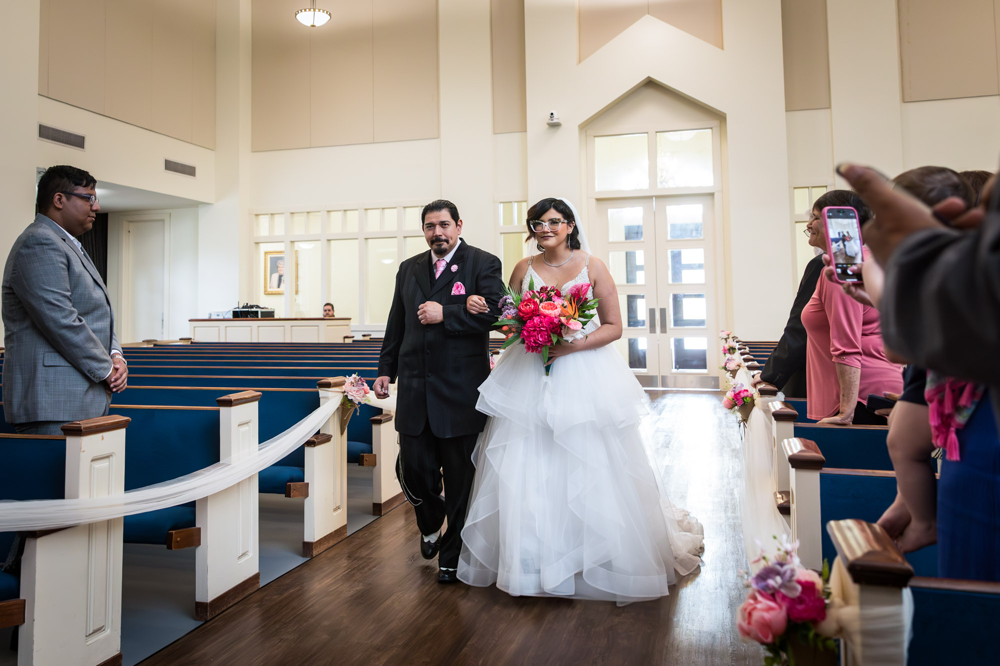 Bride and father walking down aisle in church during ceremony for an article on unexpected wedding photo tips