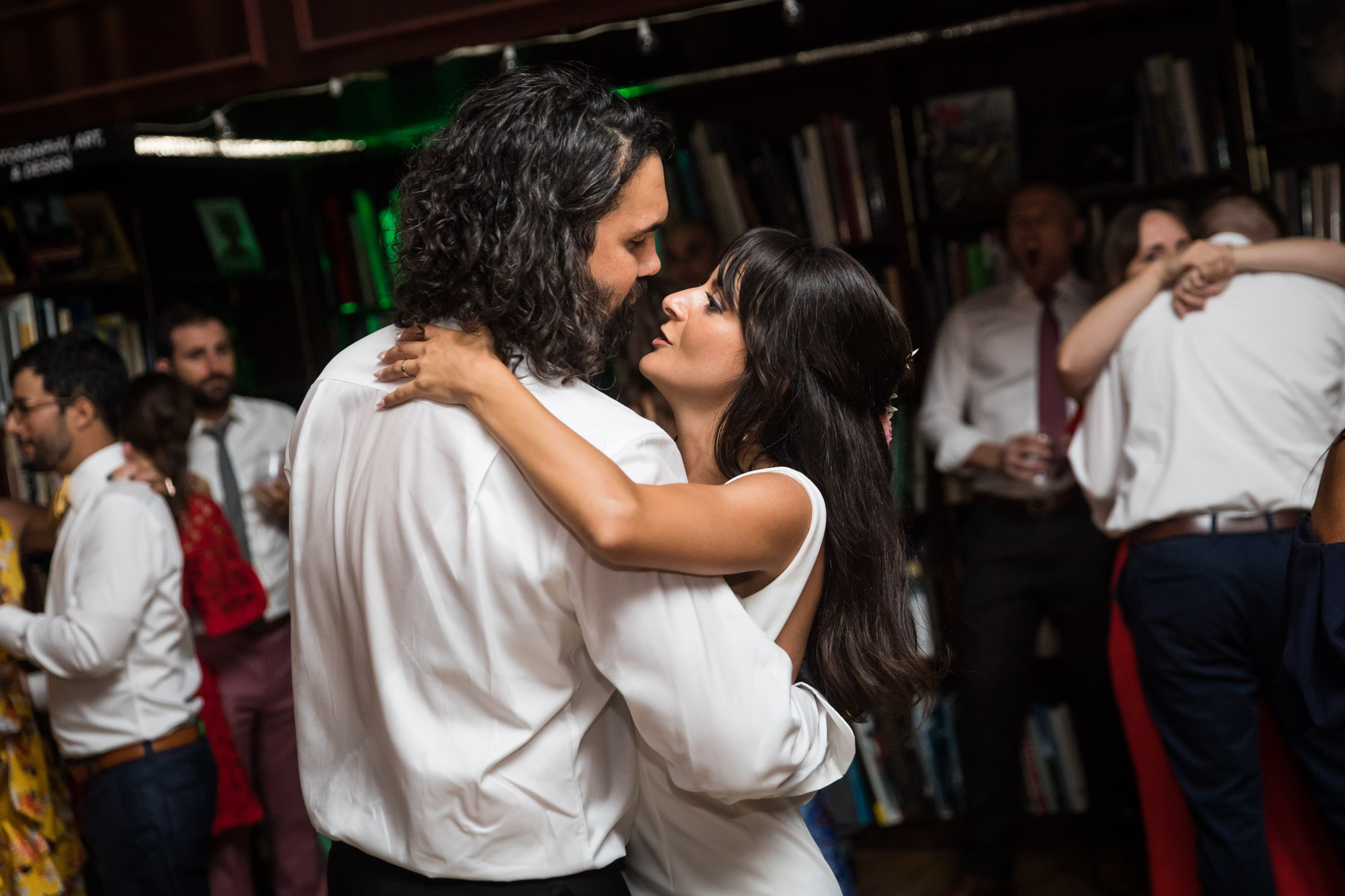 Bride and groom dancing close in front of guests while looking at each other for an article on unexpected wedding photo tips