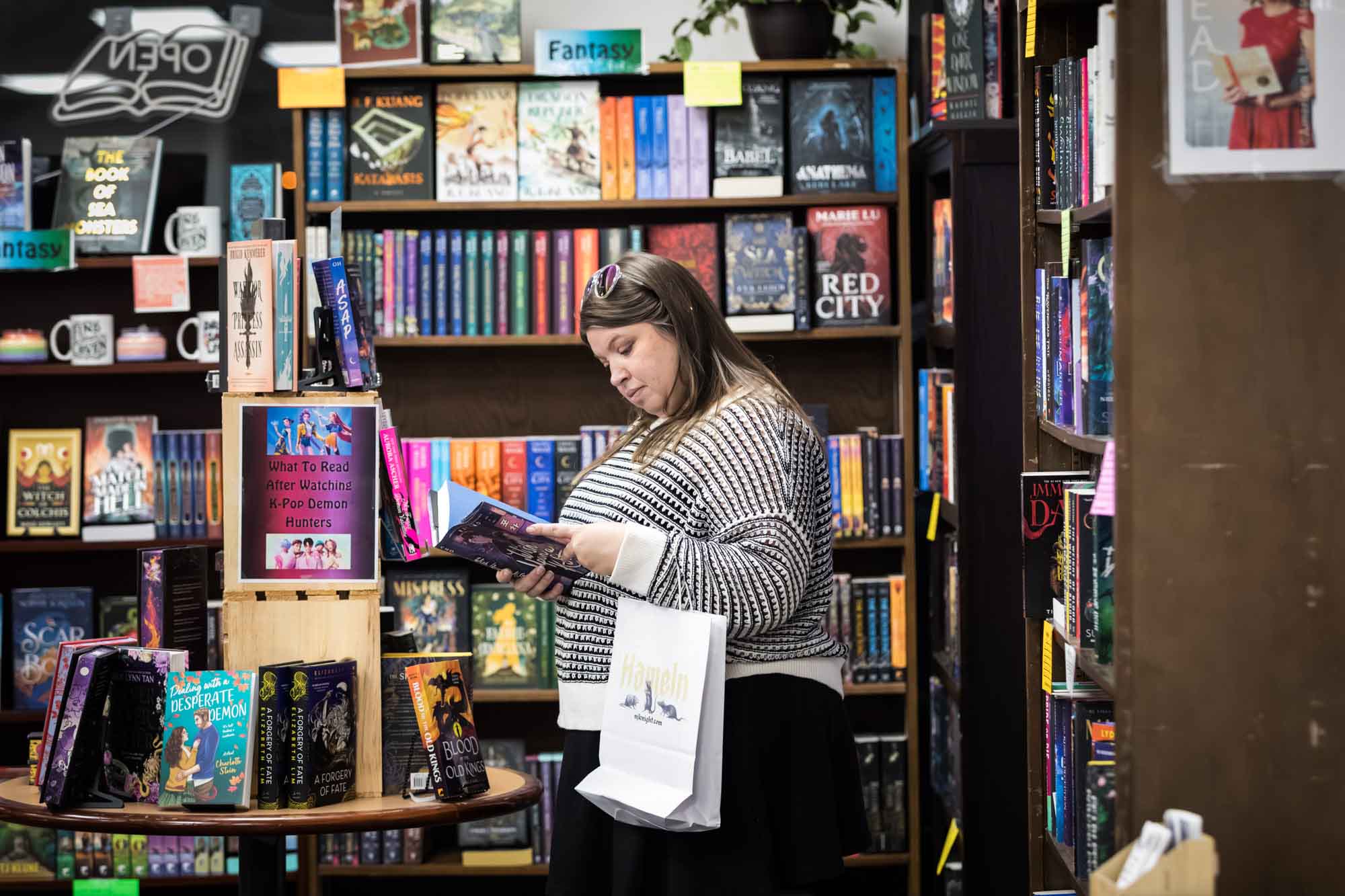 Austin book launch party photos of woman reading book in front of bookshelves filled with books at Birdhouse Books
