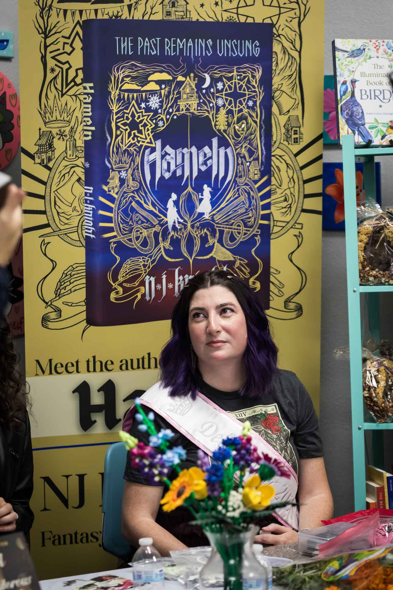 Austin book launch party photos of author Nancy Knight in front of signage announcing her book Hameln