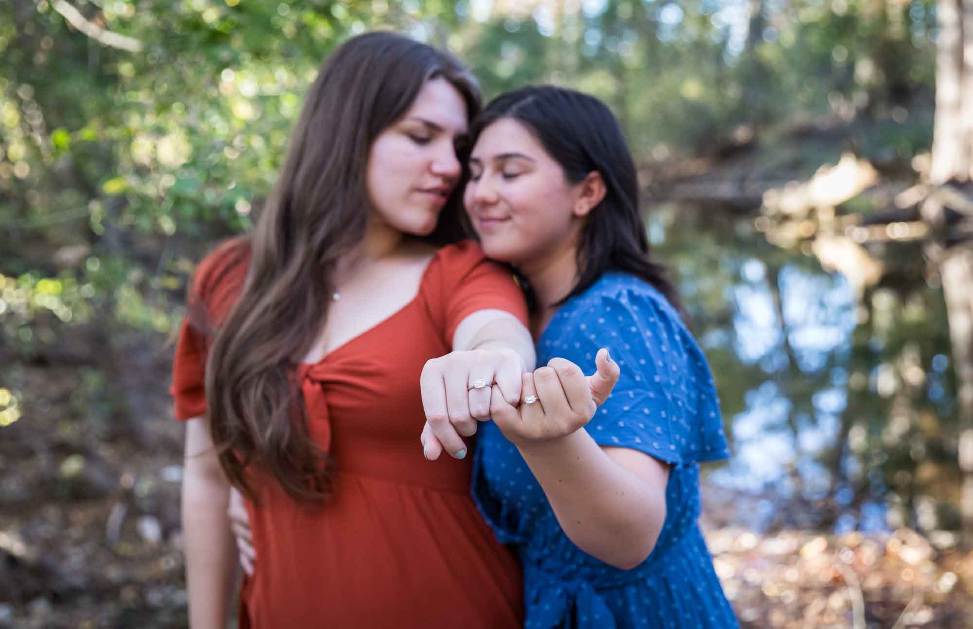 Cibolo Nature Center surprise proposal photos of two women showing hands with matching engagement rings to the camera