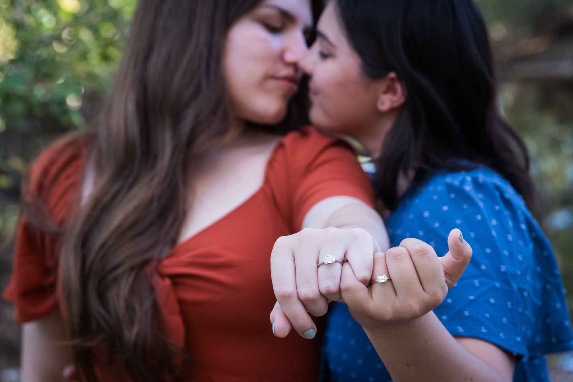 Cibolo Nature Center surprise proposal photos of two women about to kiss showing hands with engagement rings to the camera