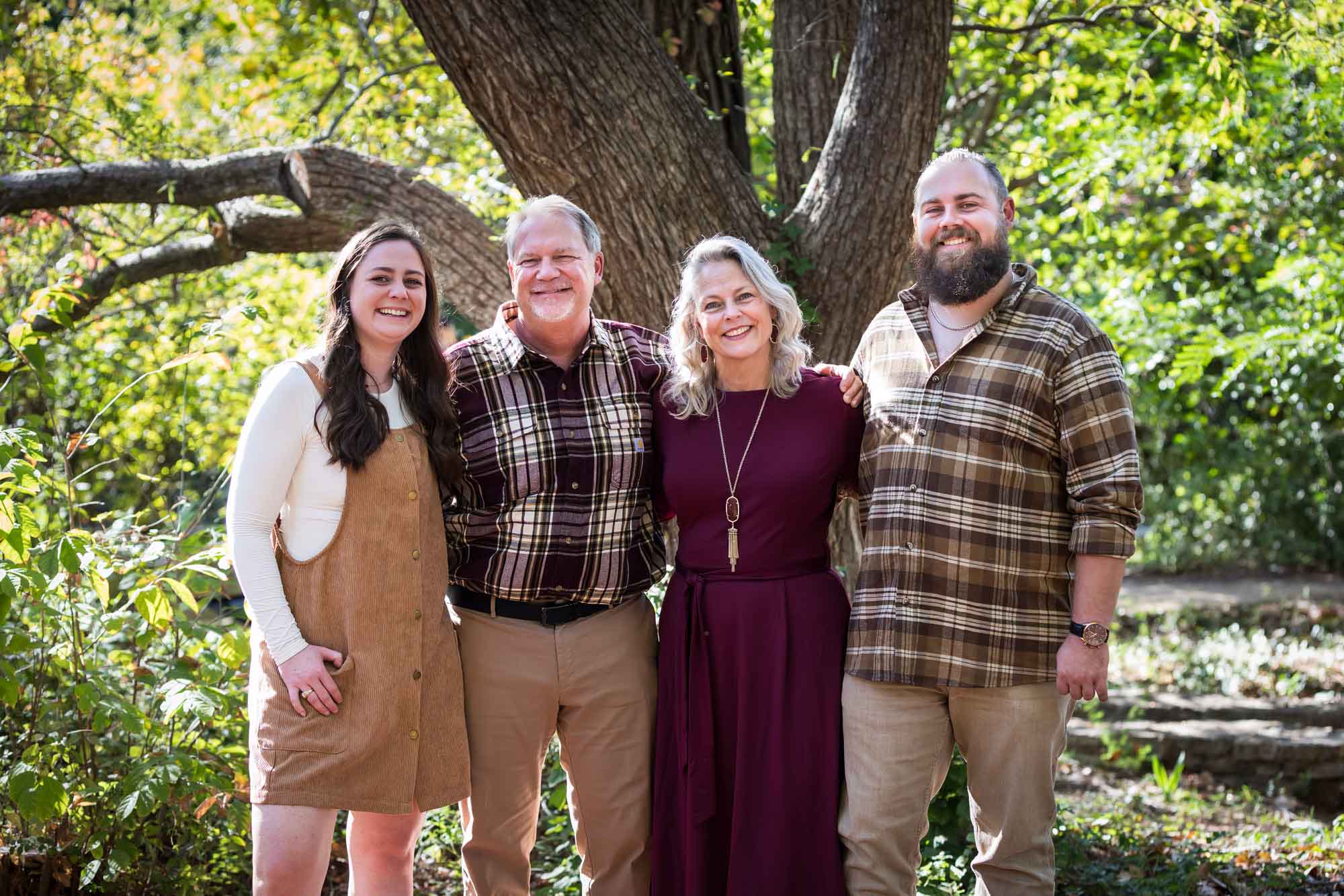 San Antonio Botanical Gardens family portrait of parents and daughter and son in front of tree and bushes