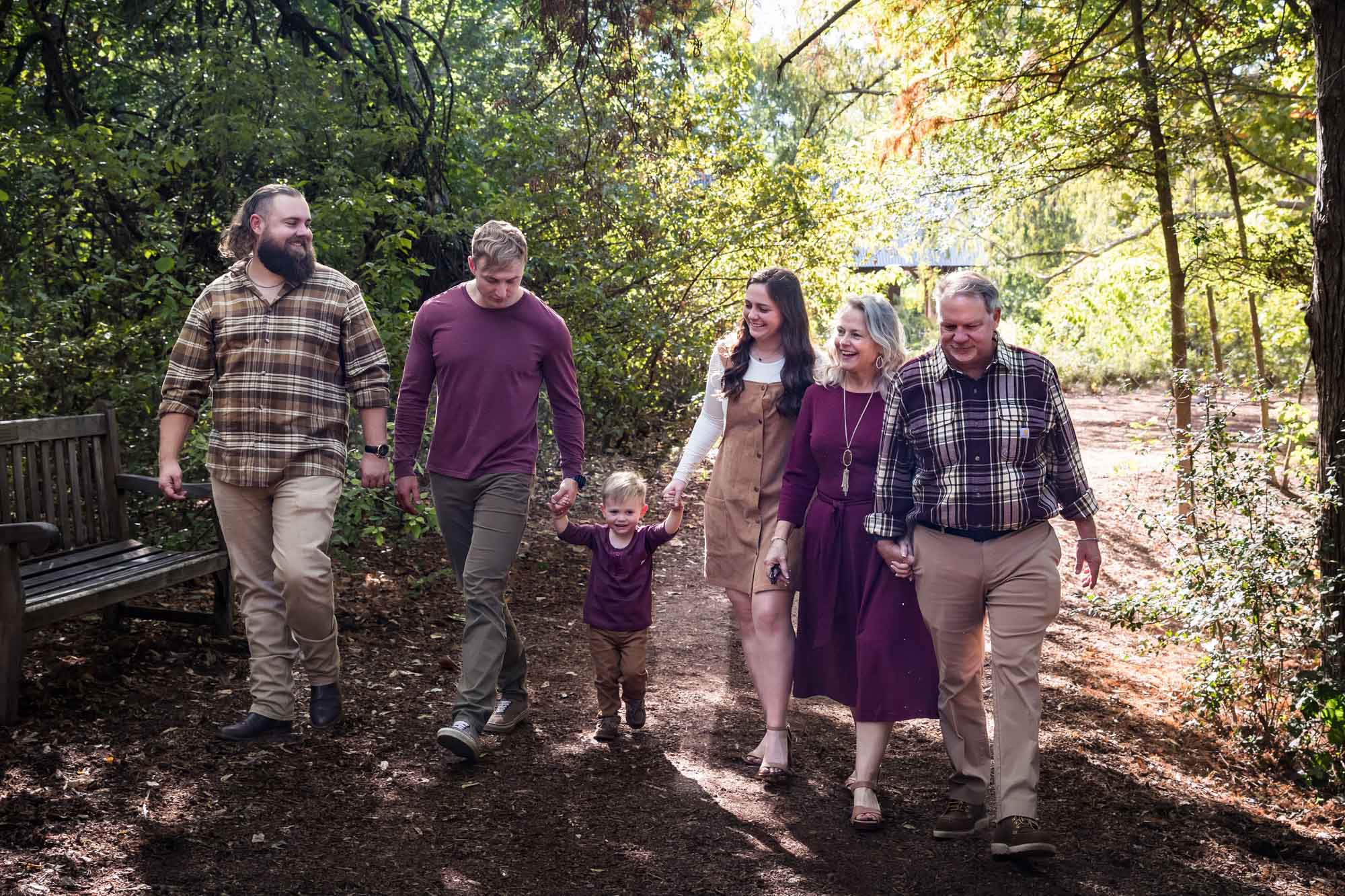 San Antonio Botanical Gardens family portrait of family walking in forest consisting of grandparents, adult brother, and mother and father holding hands of little boy