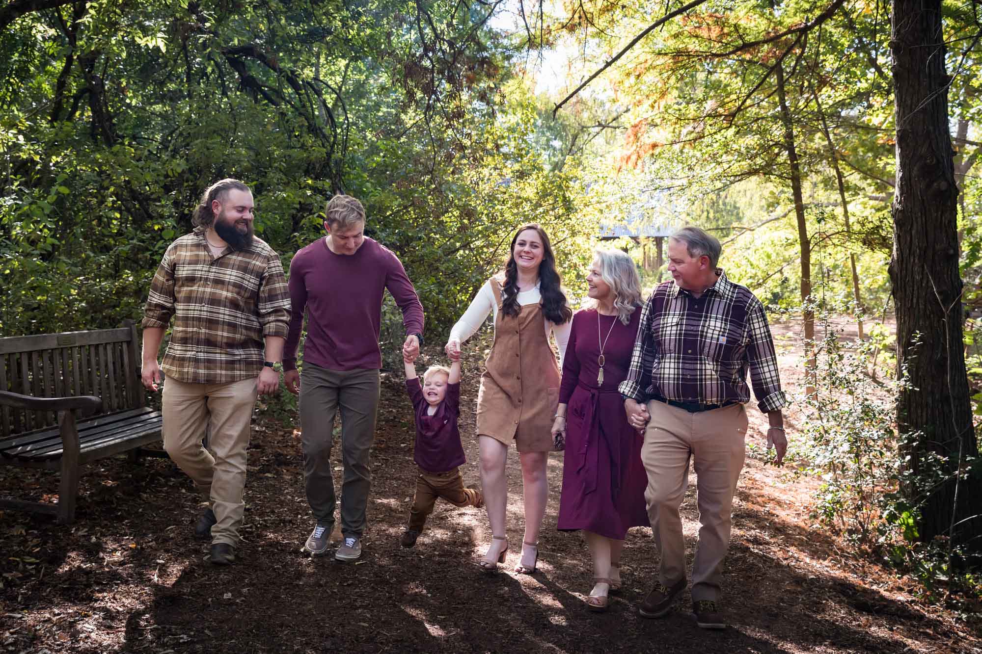 San Antonio Botanical Gardens family portrait of family walking in forest consisting of grandparents, adult brother, and mother and father holding hands of little boy