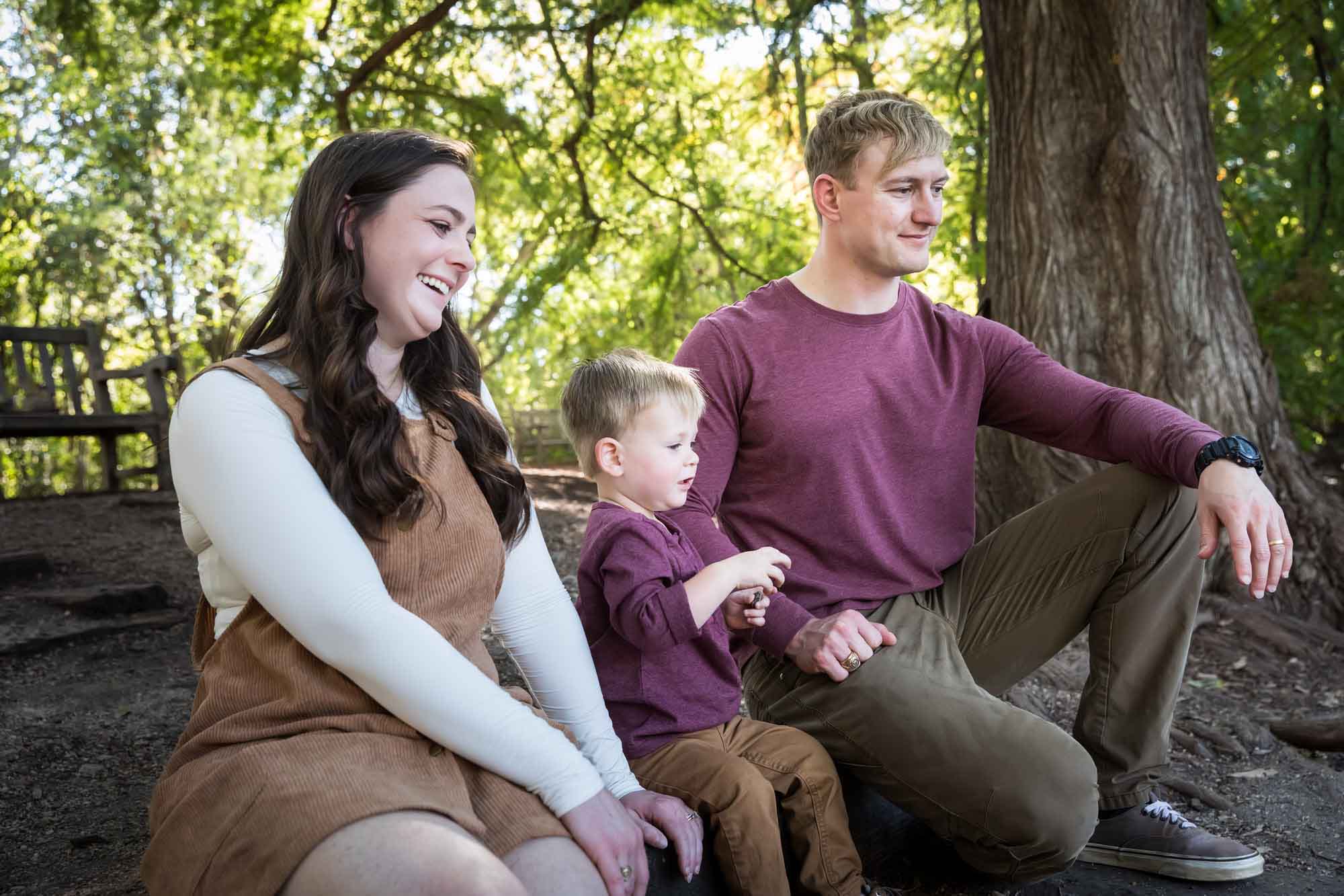 San Antonio Botanical Gardens family portrait of mother and father watching with little boy throw something in the forest