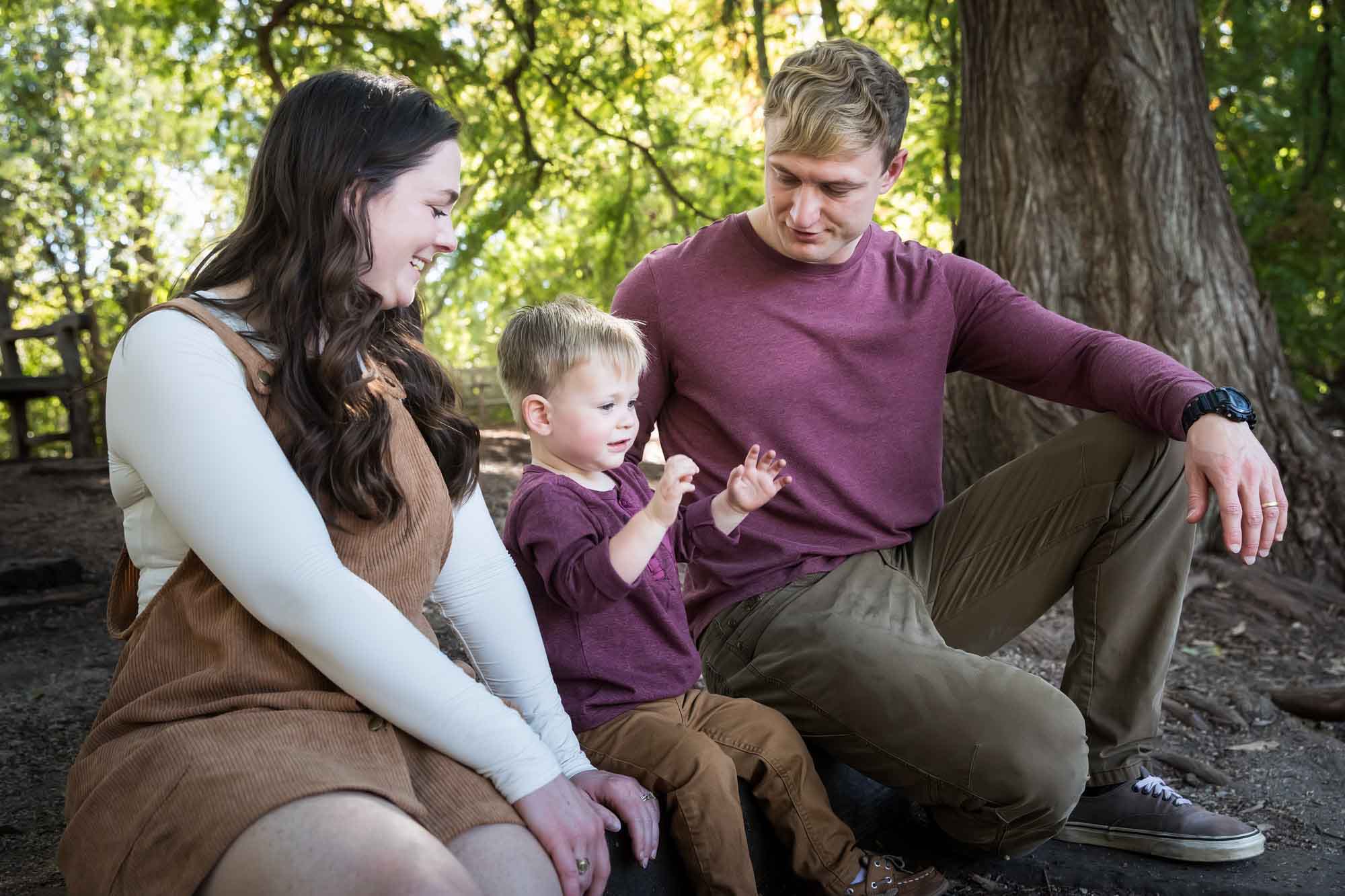 San Antonio Botanical Gardens family portrait of mother and father watching with little boy throw something in the forest