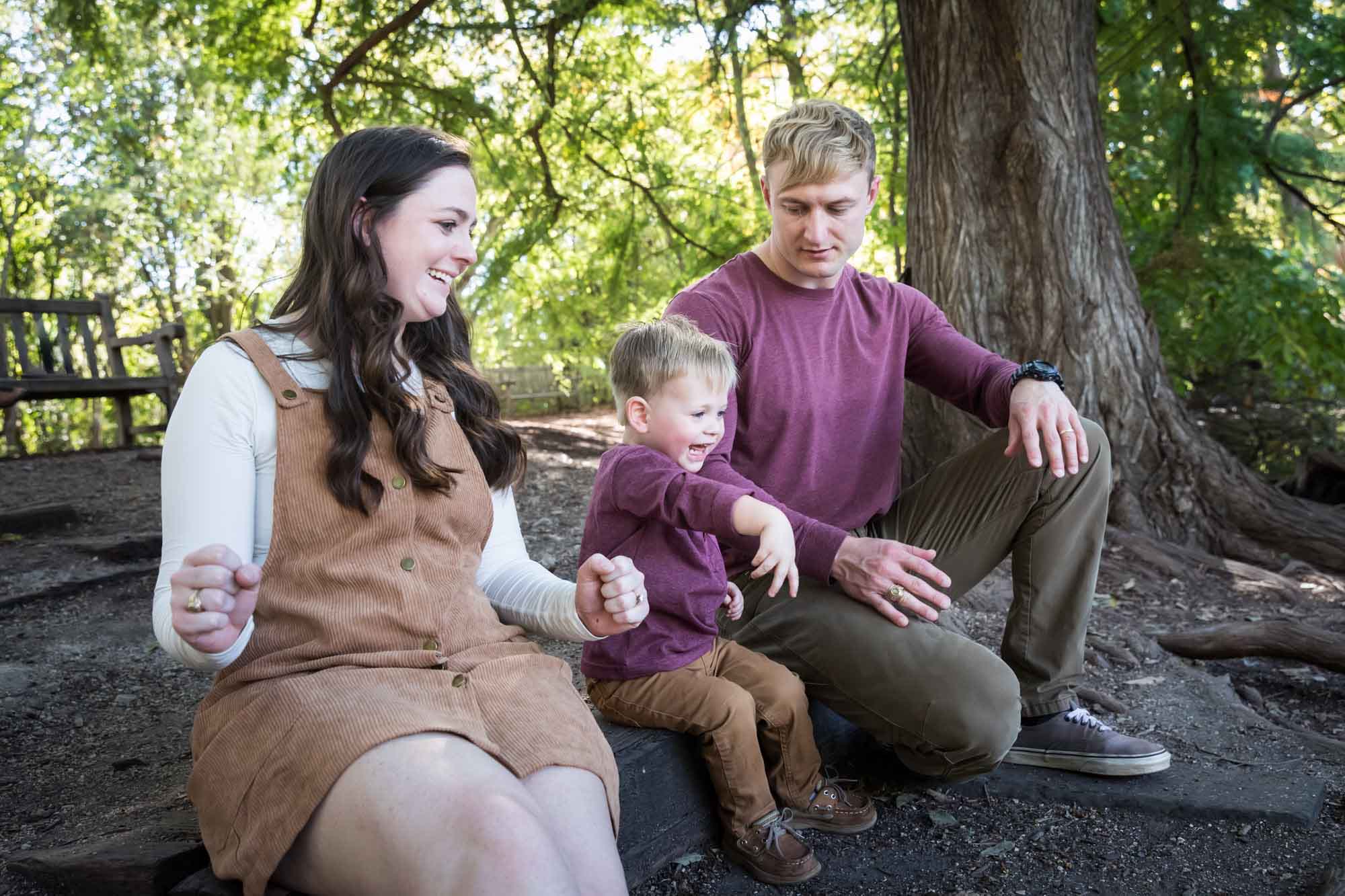 San Antonio Botanical Gardens family portrait of mother and father watching with little boy throw something in the forest